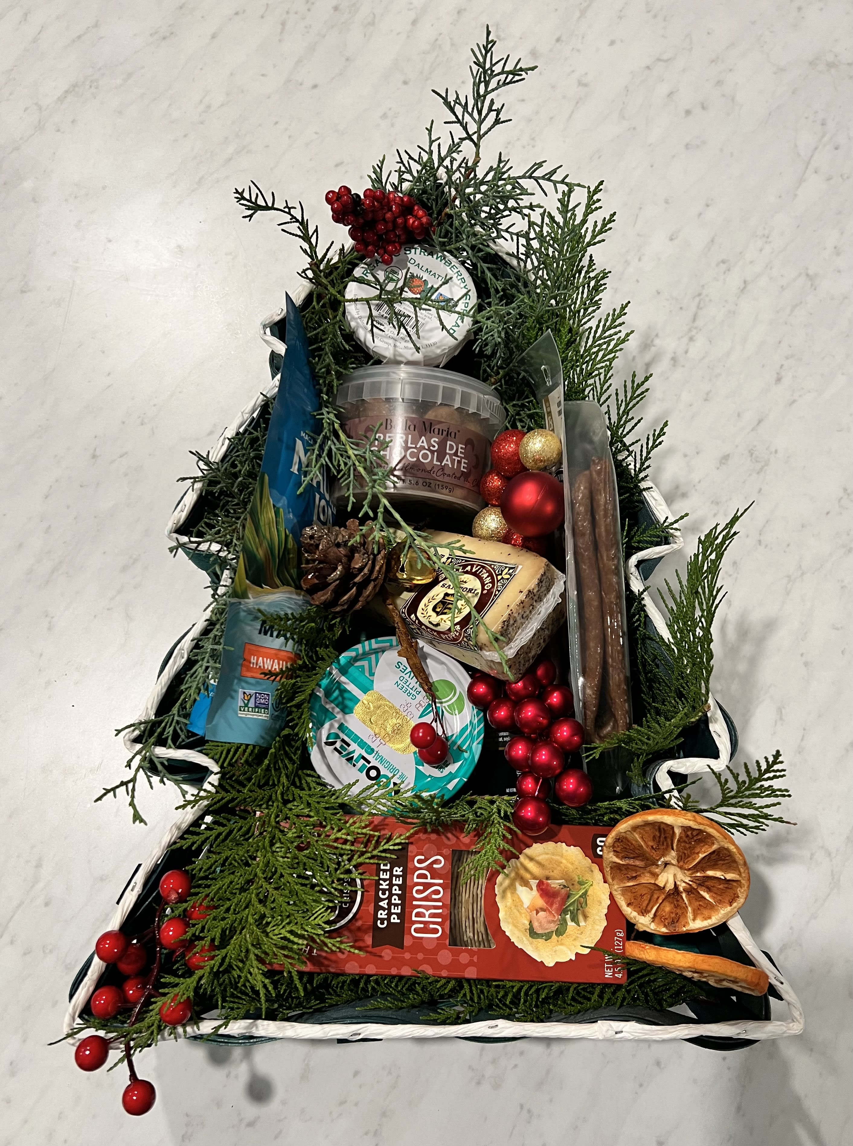 Christmas tree-shaped gift basket with snacks and ornaments