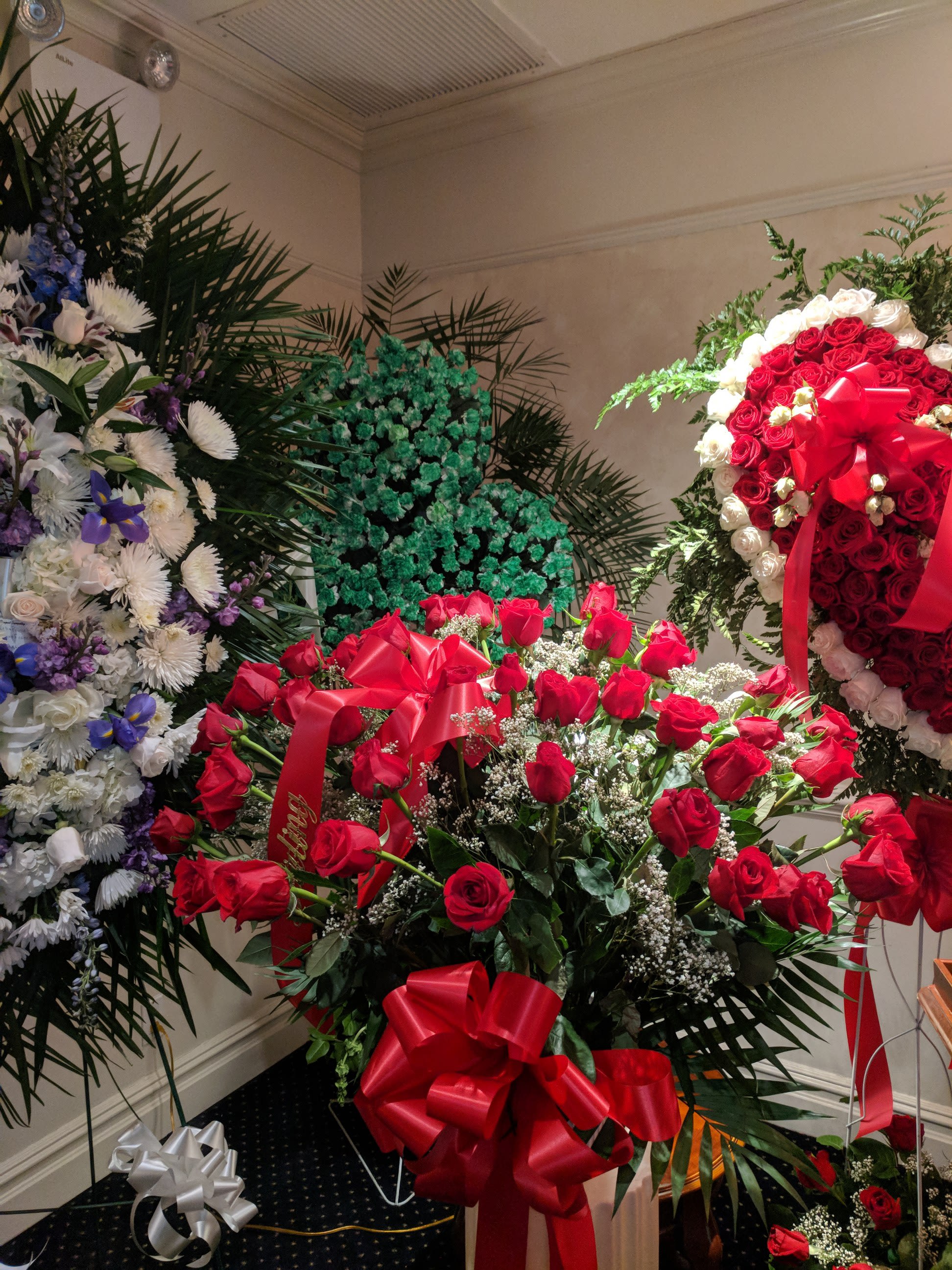 Large red rose arrangement with ribbon bows in a room