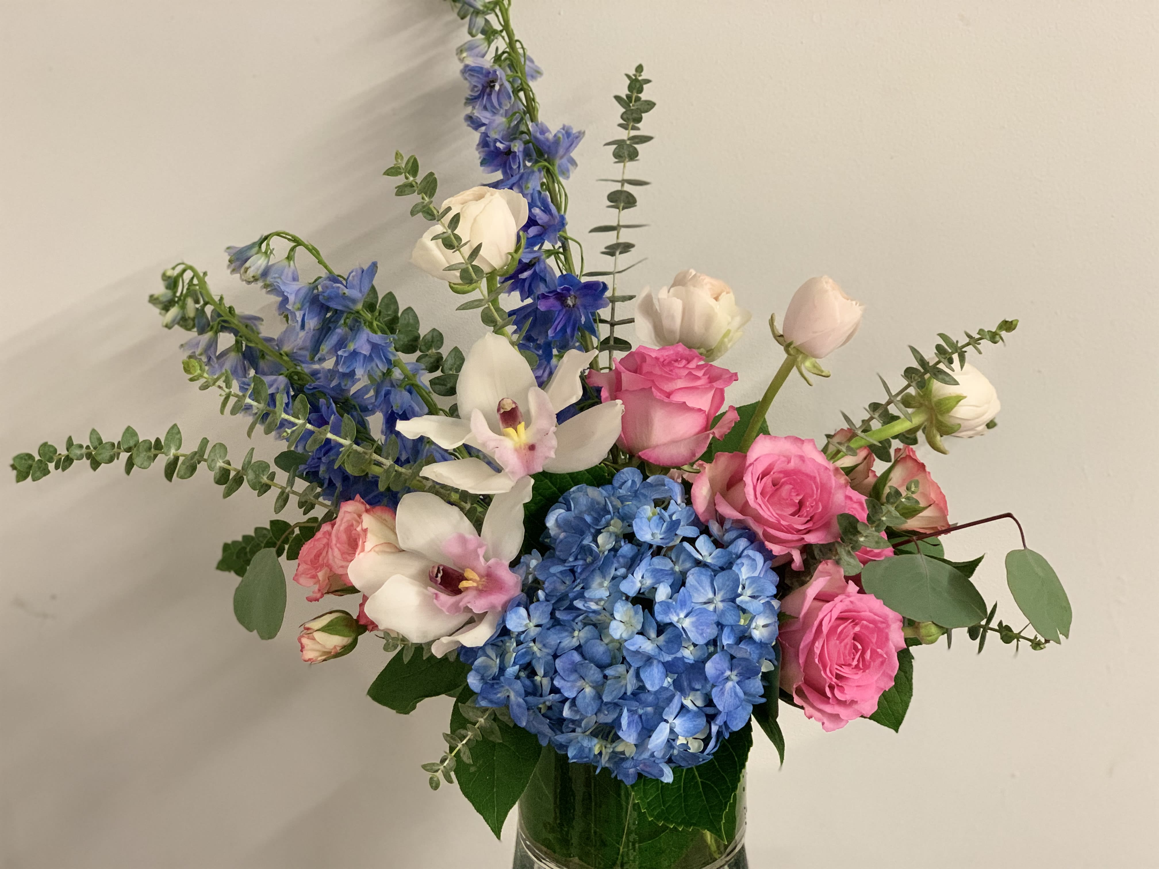 Pink roses and blue hydrangeas in a glass vase