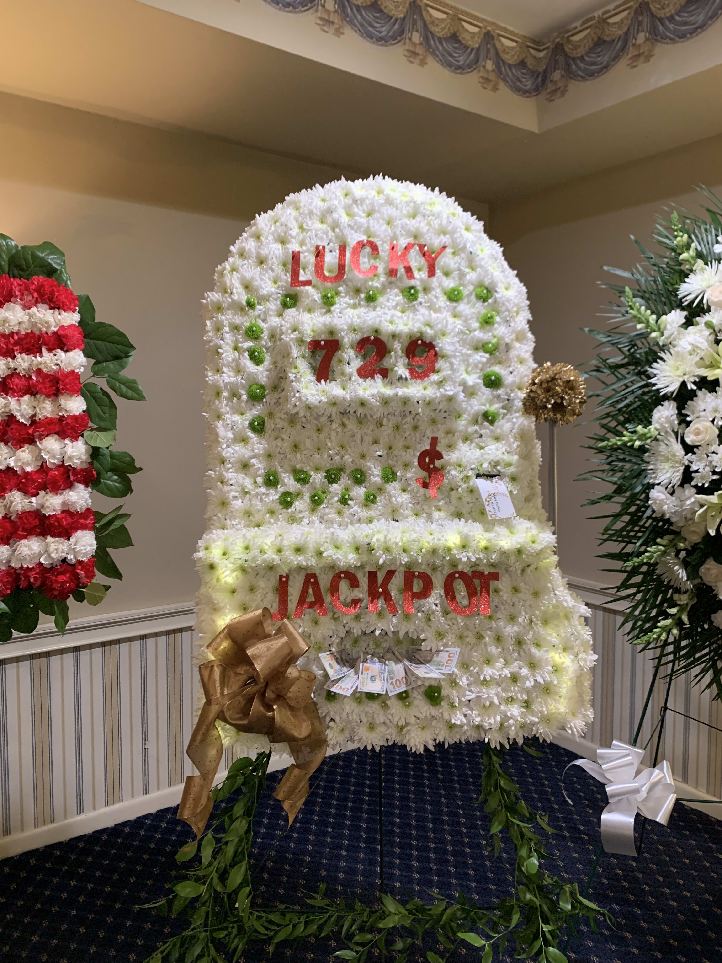 Large white floral display shaped like a slot machine with red lettering