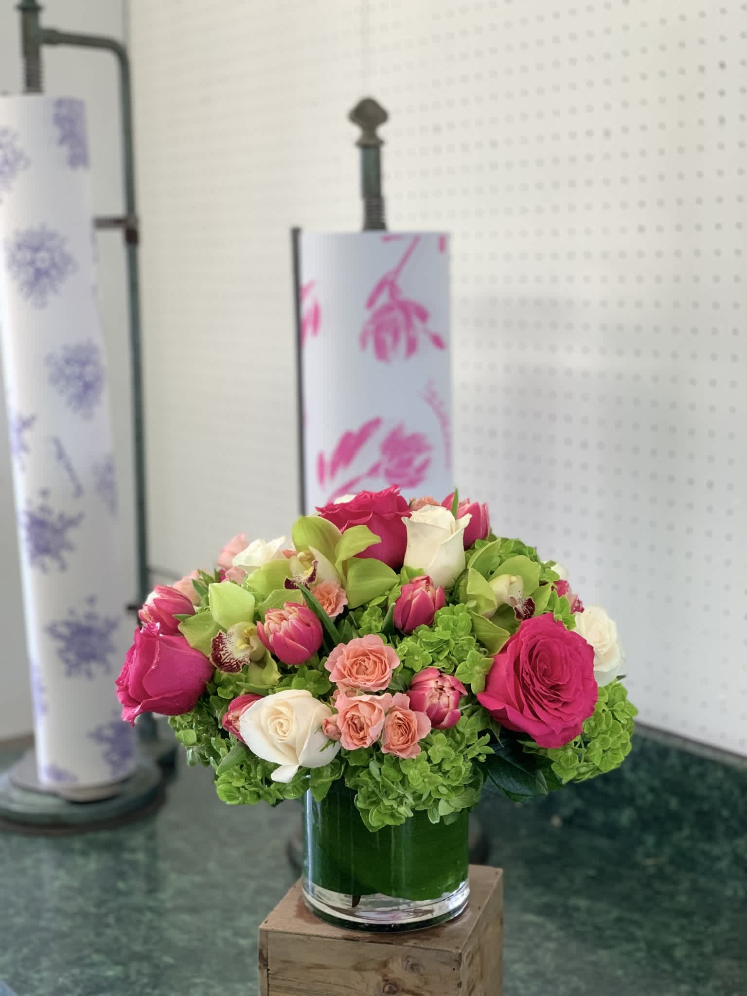 Pink and white roses with green hydrangeas in a glass vase
