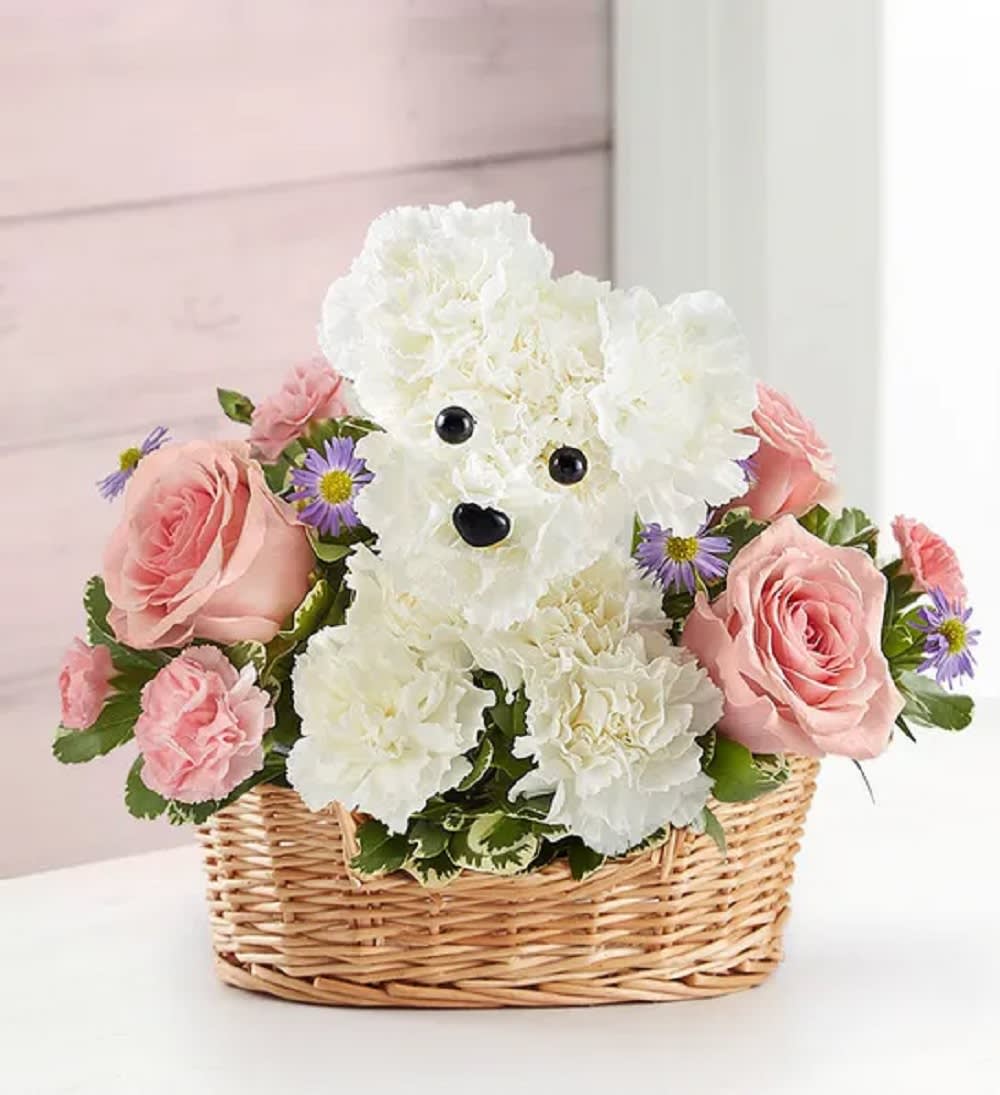 White teddy bear made of flowers in a wicker basket with pink roses