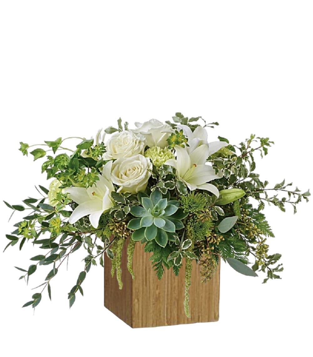 White roses and lilies in a wooden cube vase with trailing greenery