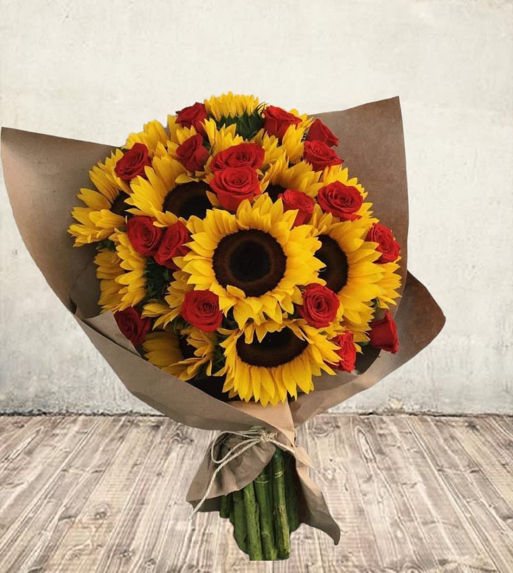 Bouquet of sunflowers and red roses wrapped in brown paper