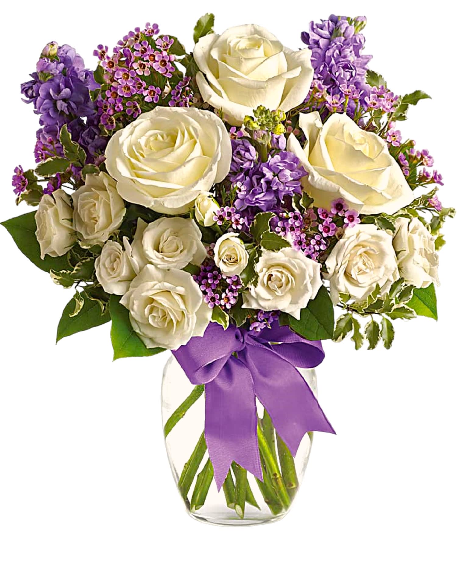 White roses and purple flowers in a clear glass vase with a purple ribbon
