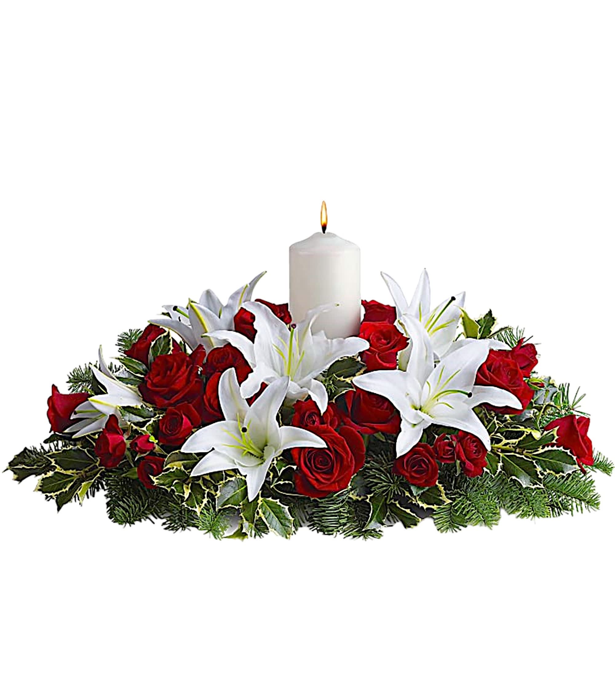 Red roses and white lilies arranged around a lit white candle