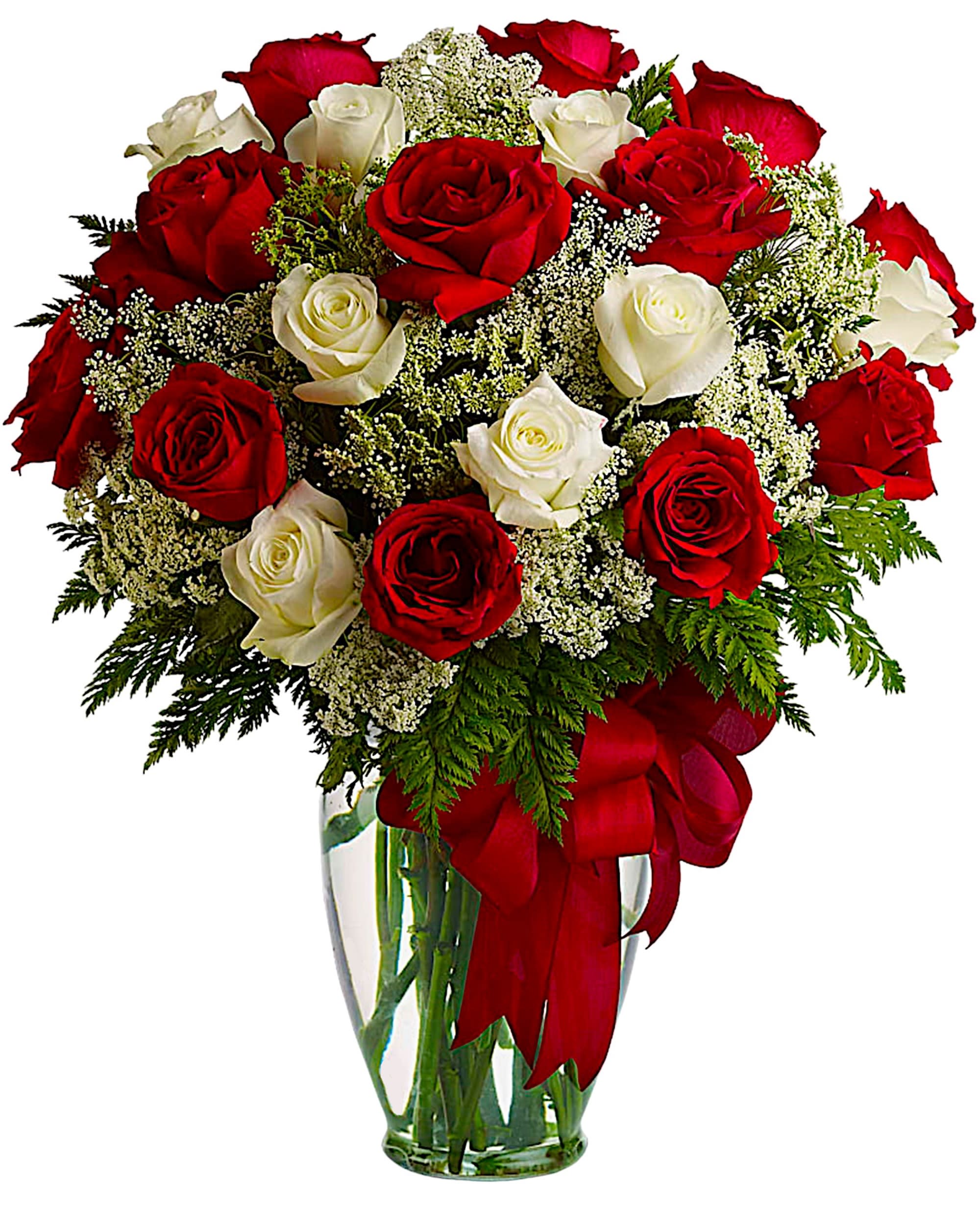 Red and white roses in a clear glass vase with baby's breath