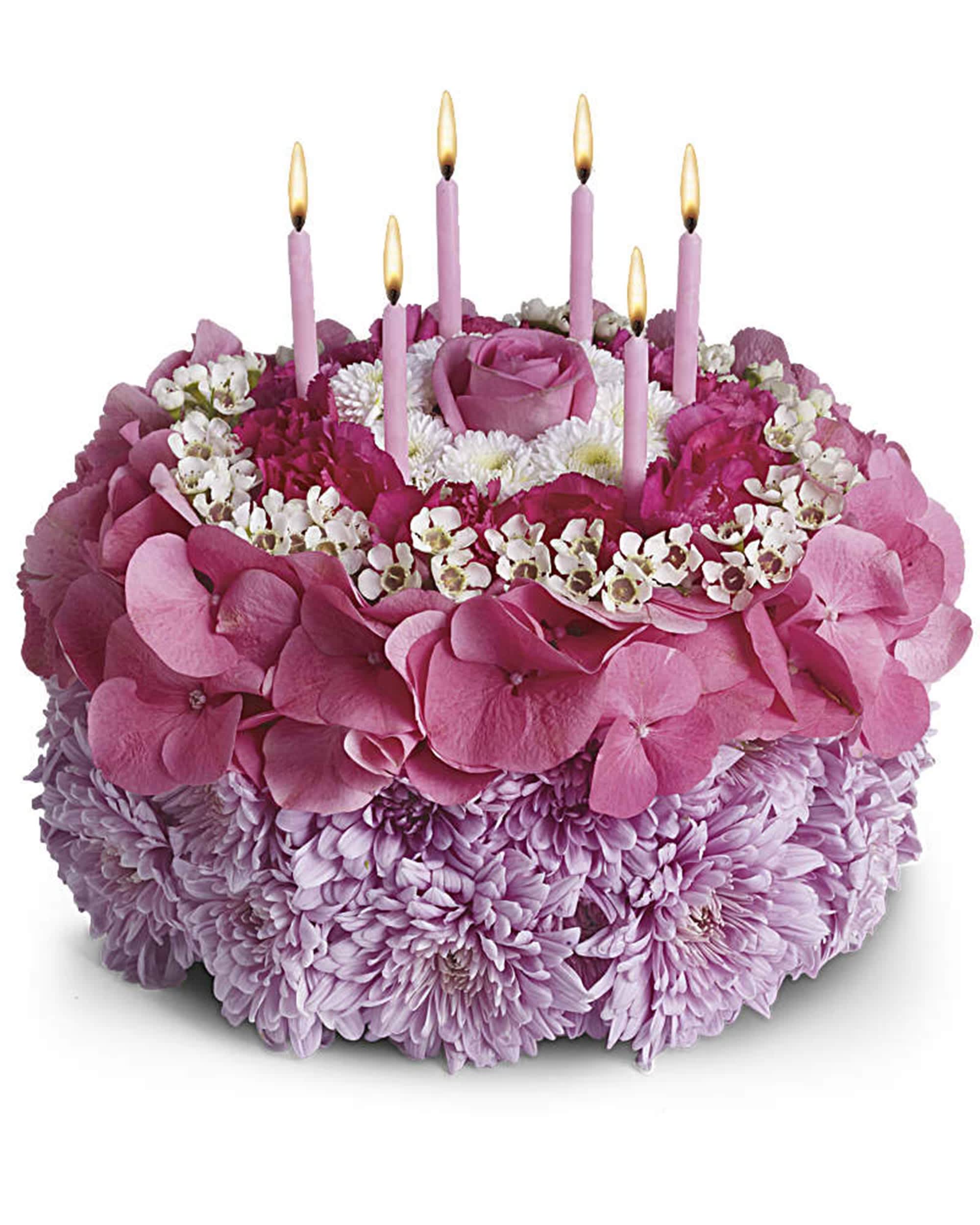 Pink floral cake with lit candles and a rose on top