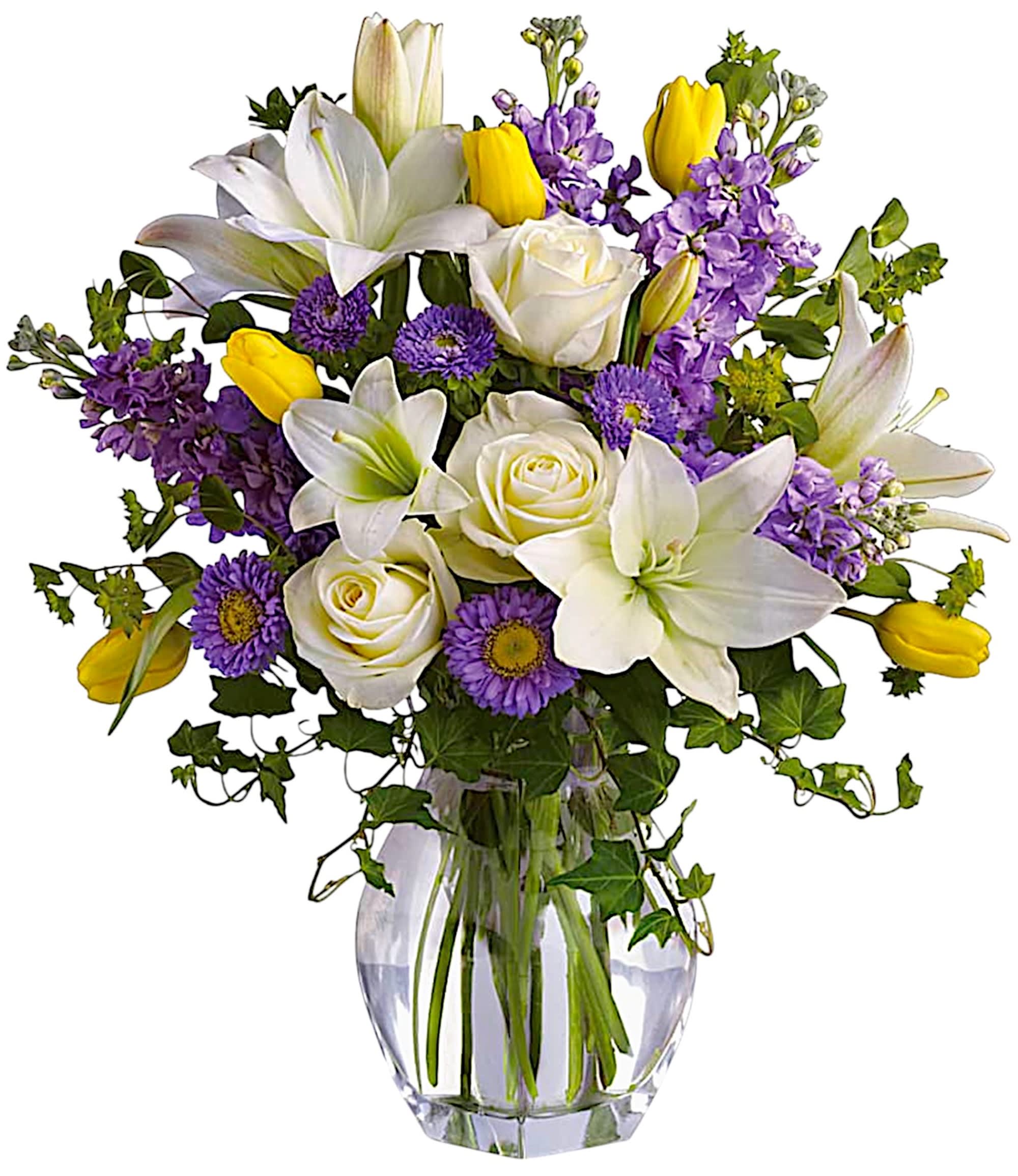 Bouquet of white lilies, roses, purple flowers, and yellow tulips in a glass vase