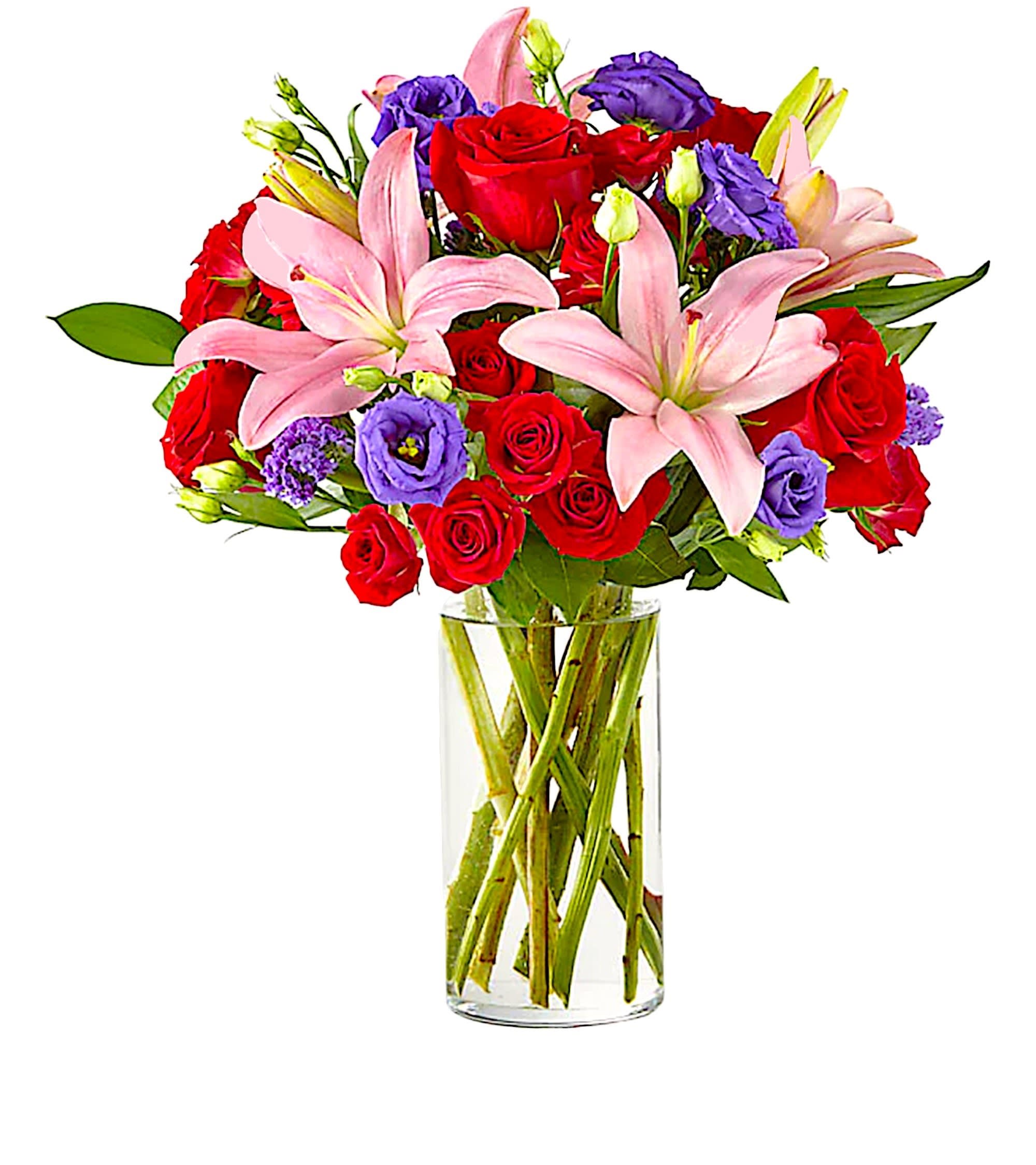 Bouquet of red roses, pink lilies, and purple flowers in a clear glass vase