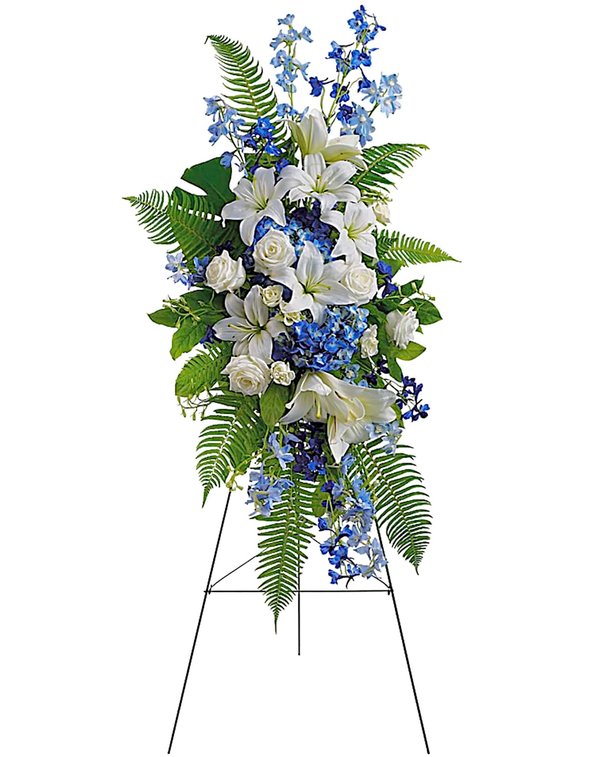 Tall standing floral spray with white lilies, white roses, and blue flowers