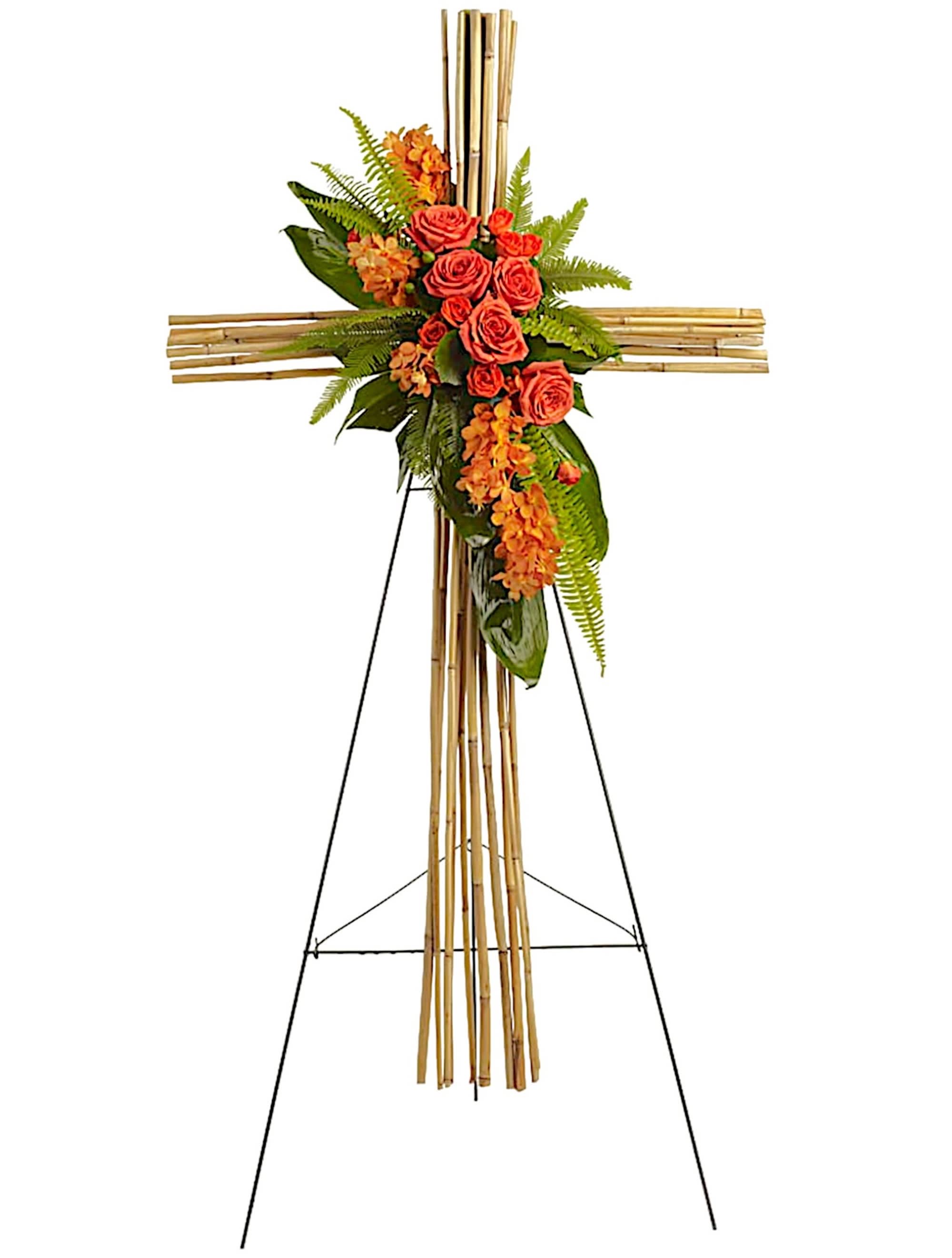 Floral cross on an easel with orange roses and greenery