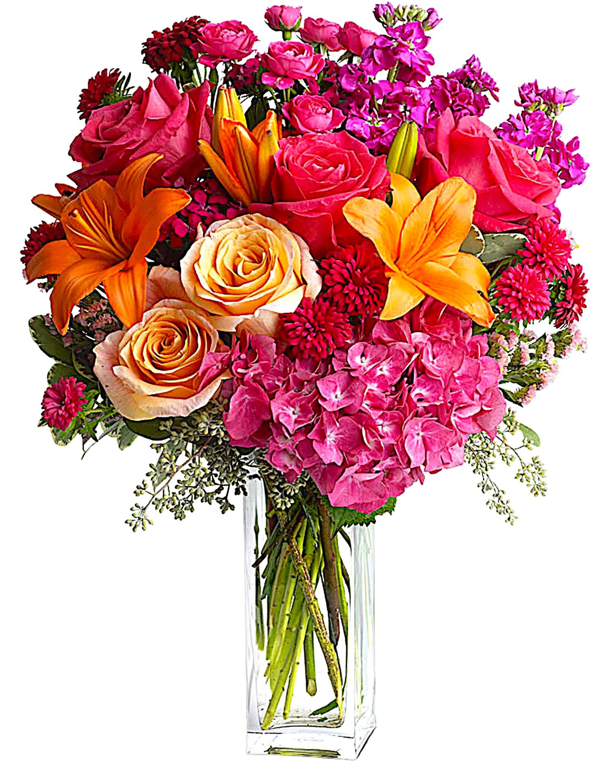 Bouquet of pink roses, orange lilies, and hot pink hydrangeas in a clear vase