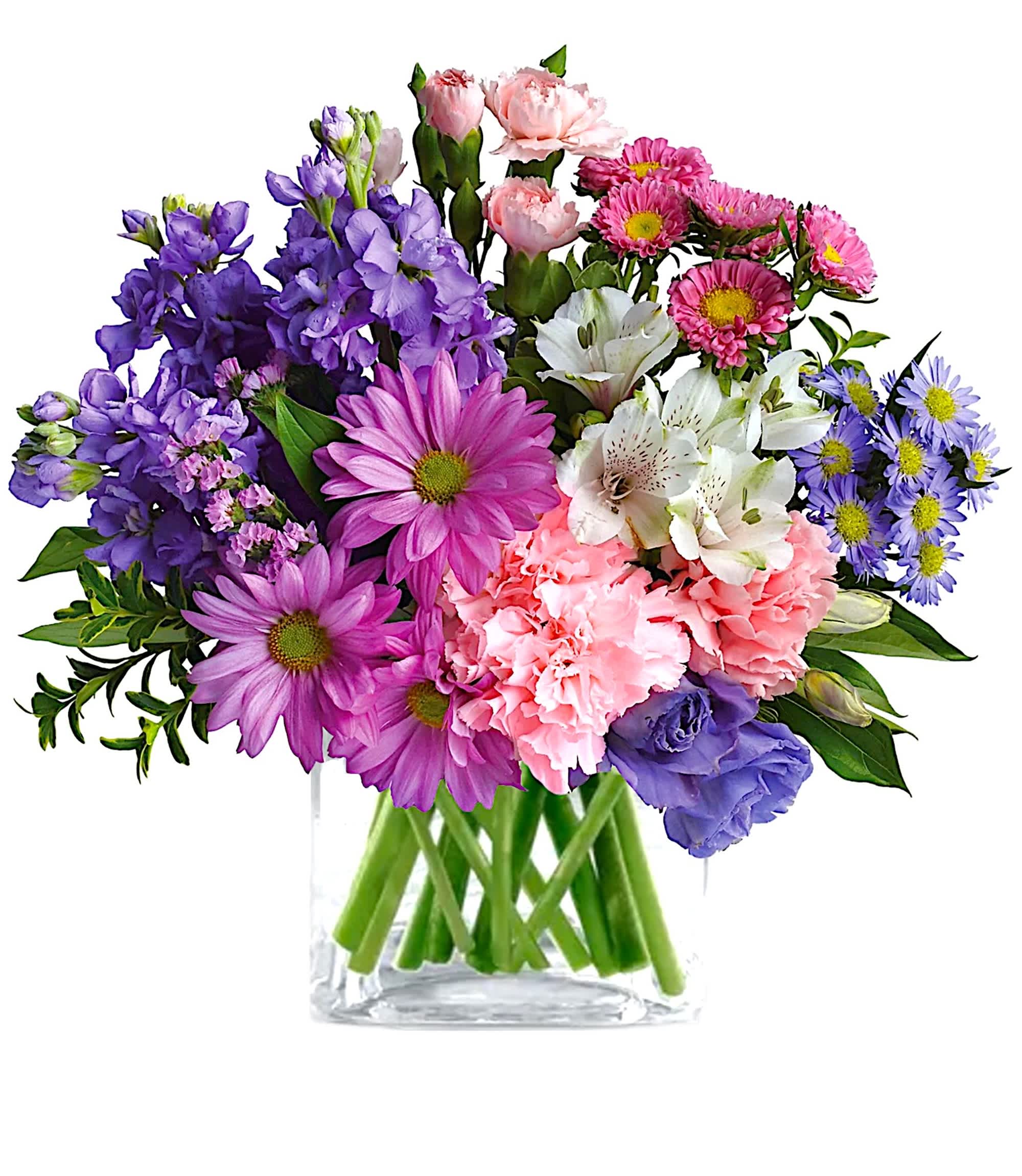 Mixed bouquet of purple, pink, white, and blue flowers in a clear glass vase