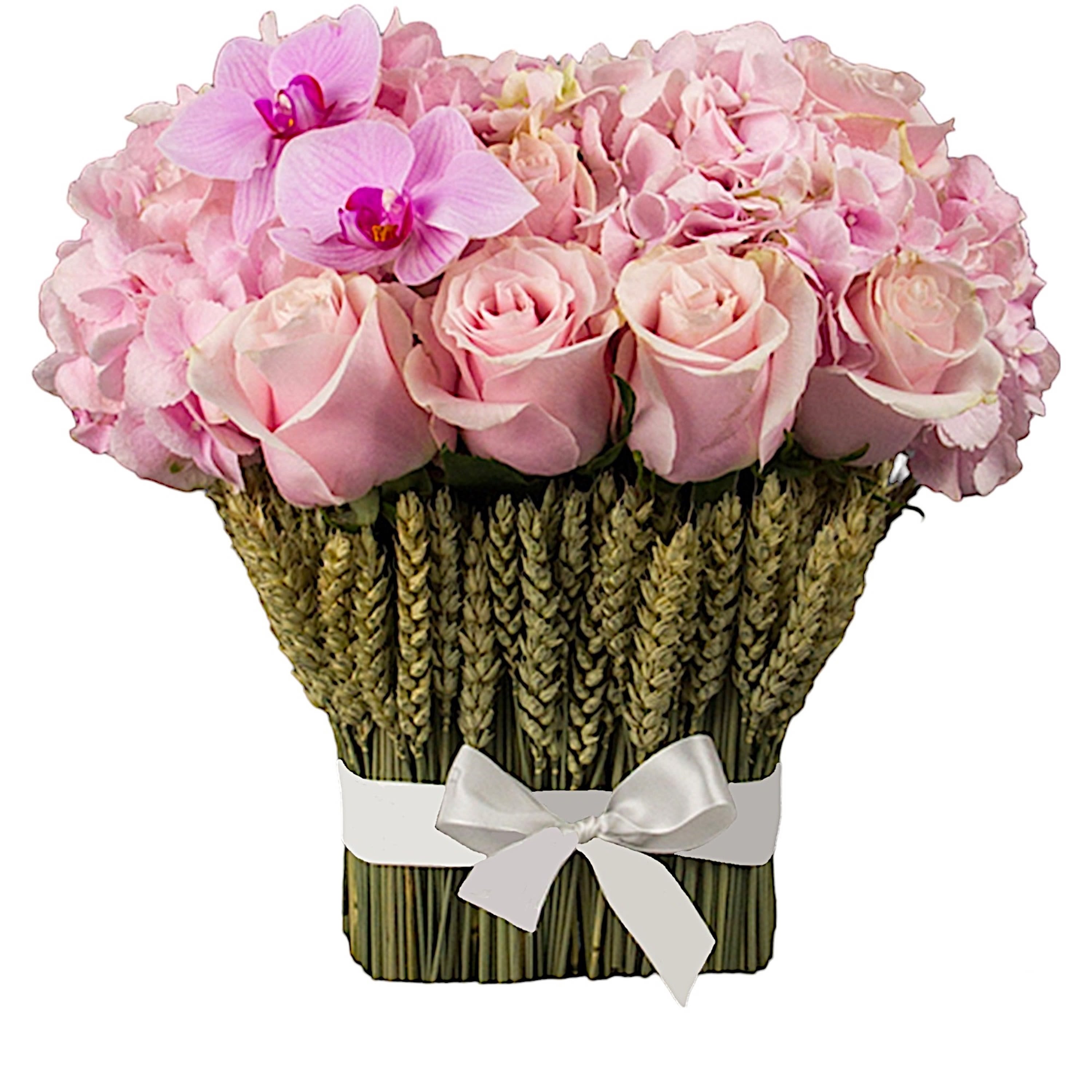 Pink roses and orchids arranged in a woven basket with a white ribbon