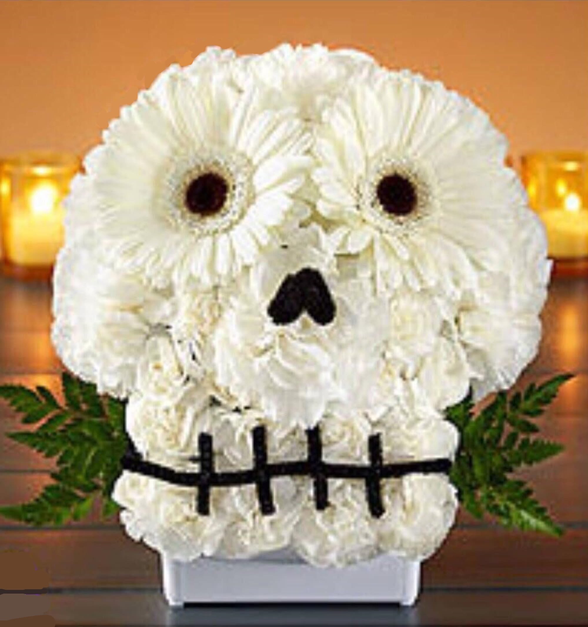 White flower arrangement shaped like a skull with dark eye and nose accents