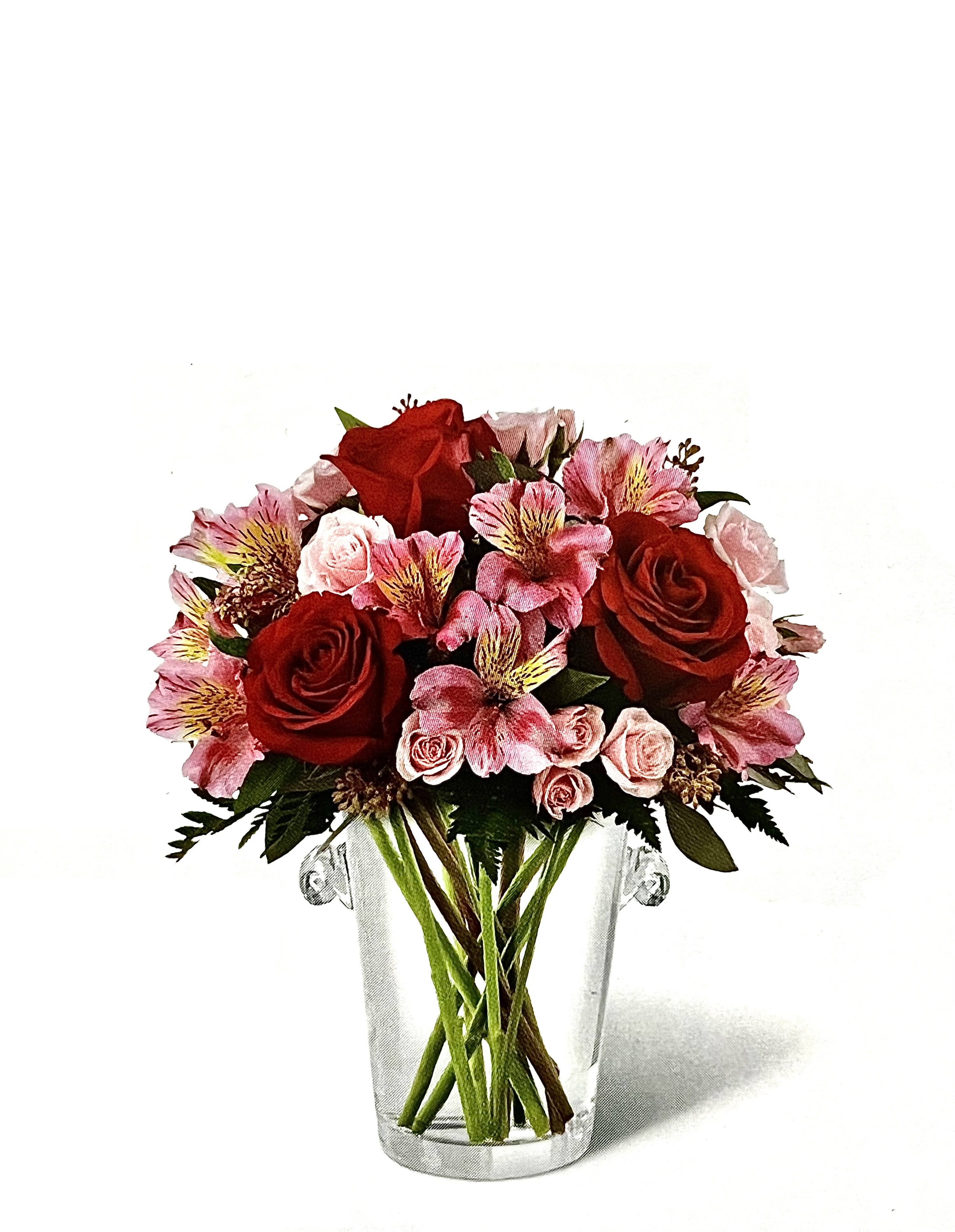 Red and pink flower bouquet in a clear glass vase