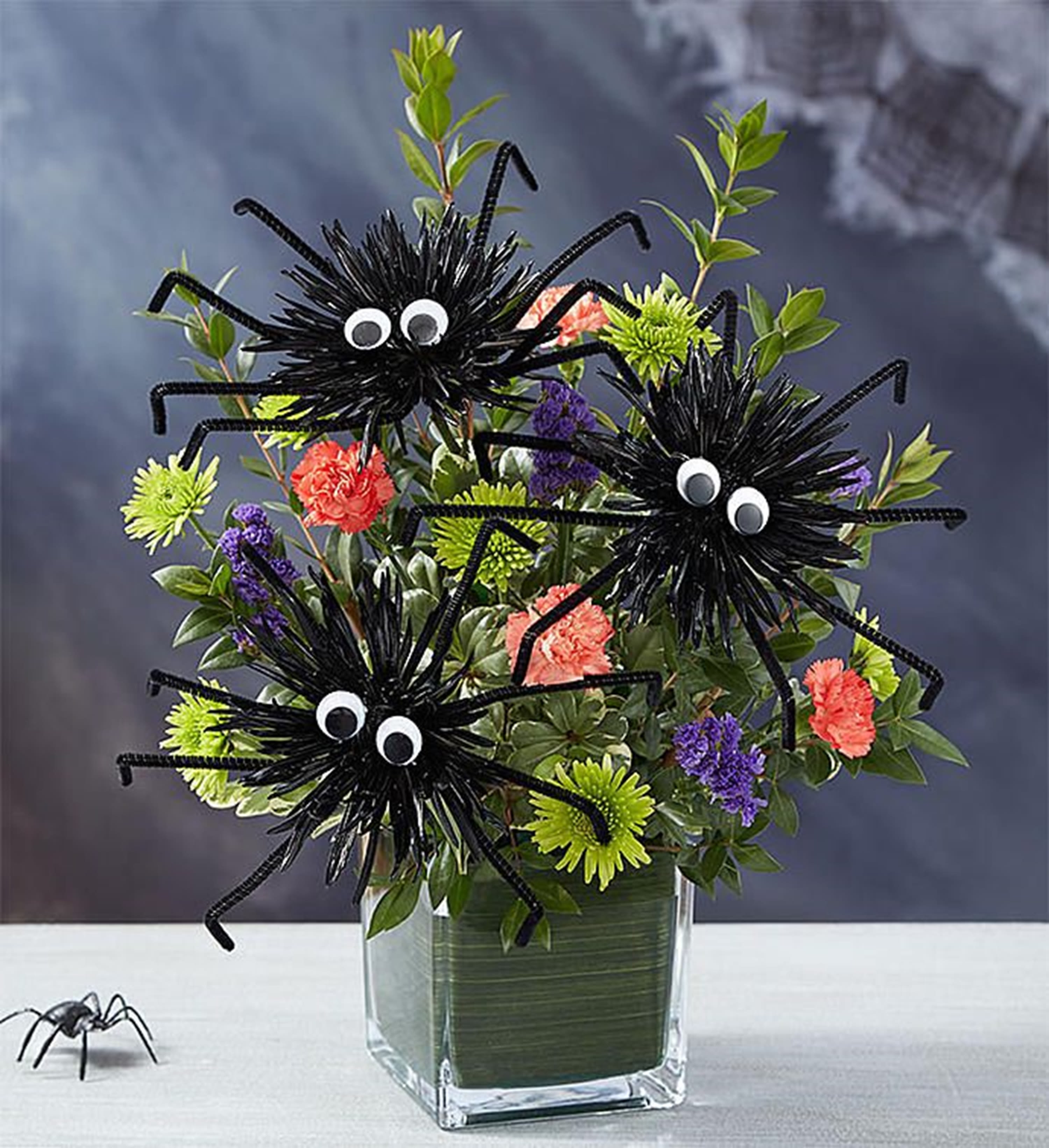 Halloween bouquet with spider decorations in a glass vase