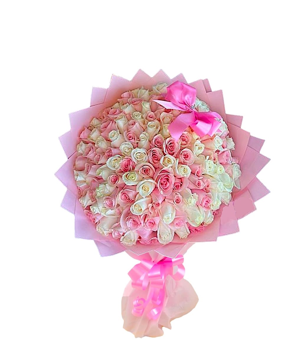 Large bouquet of pink and white roses wrapped in pink paper with a ribbon