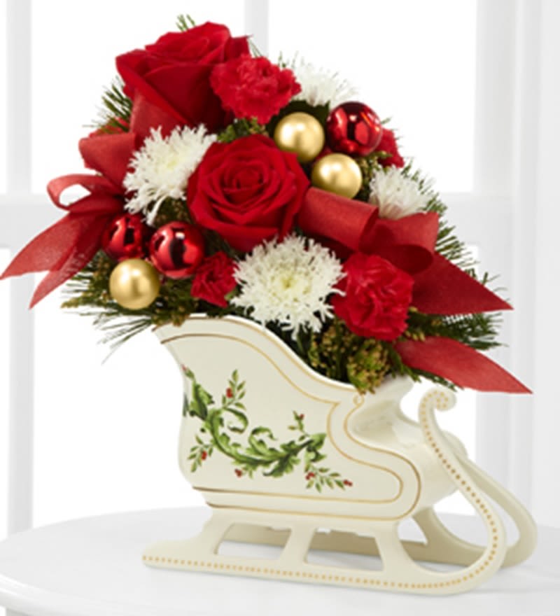 Holiday Traditions Arrangement - The Holiday Traditions Arrangement speaks to the beauty and magic of the holiday season.   DETAILS Rich red roses, white chrysanthemums, red mini carnations and lush holiday greens are gorgeously arranged in a designer ceramic sleigh while accented with red and gold holiday ornaments and red ribbon, to create a wonderful way for you to convey your warmest season’s greetings.  SLEIGH INCLUDED Orientation: All-Around Item #NF-794  FLORIST-TO-DOOR Same day flower delivery on most orders placed online by 12 pm or 10 am on weekends PST.  BLOOM DETAILS Roses Mini-Carnations Snowflake-Mums Greenery  The Standard Arrangement is approx. 12" H x 11" W. The Deluxe Arrangement is approx. 13" H x 12" W. The Premium Arrangement is approx. 14" H x 13" W.  How to place an order? 1. You can place an order directly on this secure website OR 2. You can call in your order by dialing: (323) 262 - 9238 OR 3. You can visit our store (appointment recommended 323.262.9238)  NINFA'S FLOWERS 2405 WHITTIER BLVD. LOS ANGELES, CA. 90023  ATTENTION: *Please note that on busy holidays, Valentine's Day, and Mother's Day, we cannot verify if the recipient received the flowers until the following day. You can verify delivery on the website after 10:00 pm, call 323.262.9238 the following day after 10:00 am, or contact the recipient directly. Thank you for your patience and understanding. 