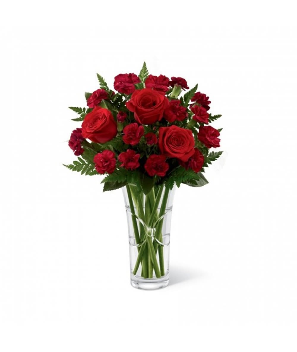 Red roses and carnations in a clear glass vase