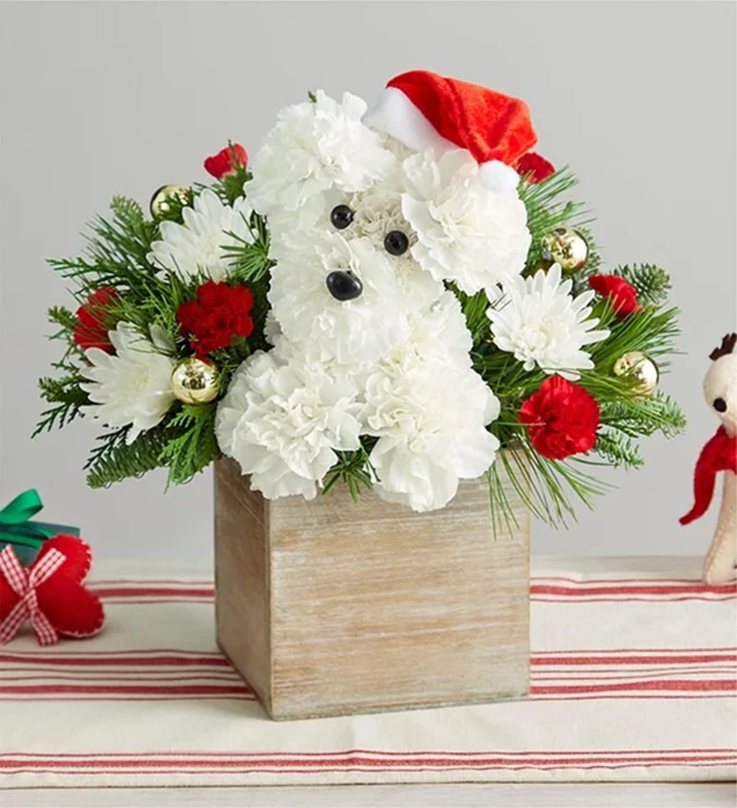 White floral dog arrangement in a wooden box with a Santa hat