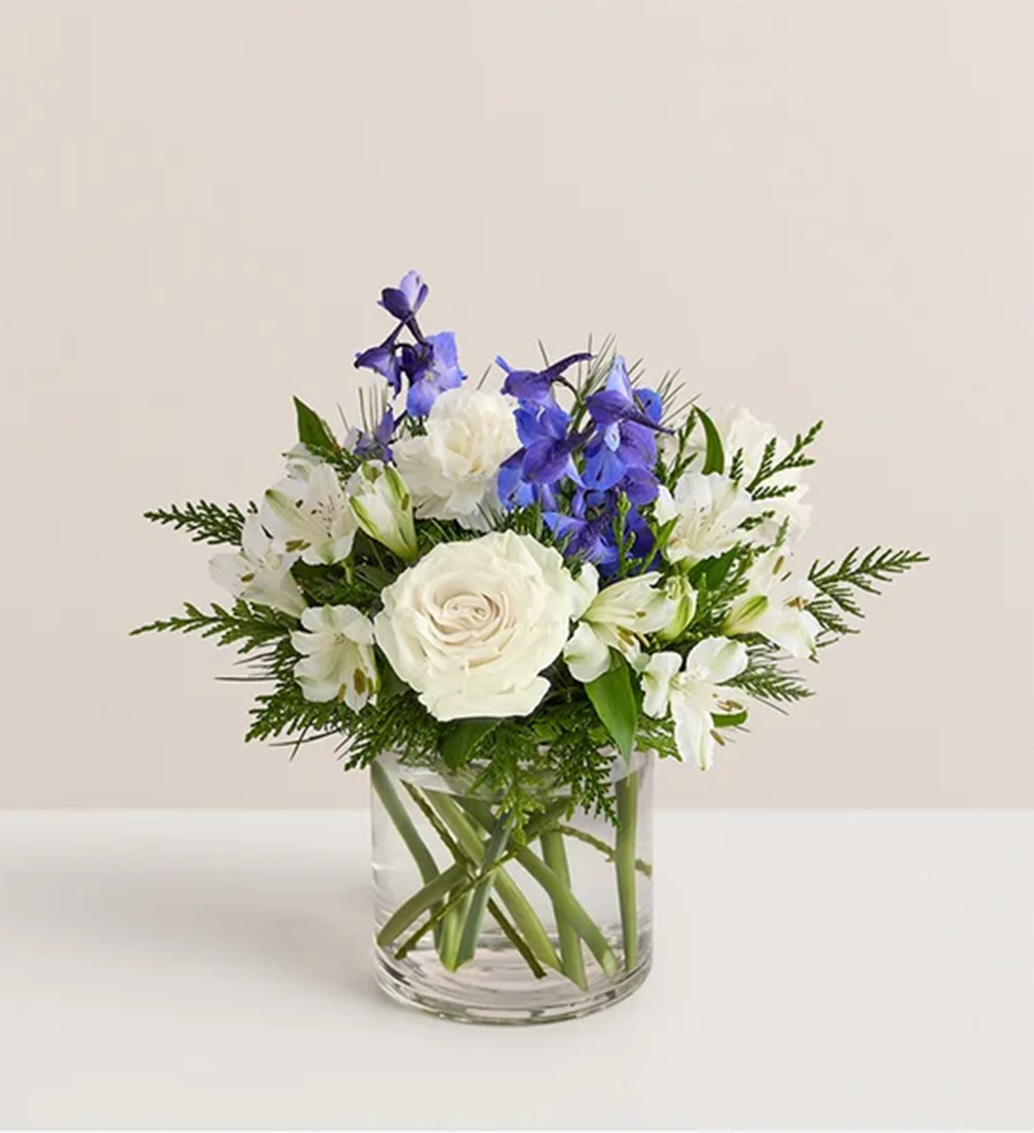 White and blue flowers arranged in a clear glass vase