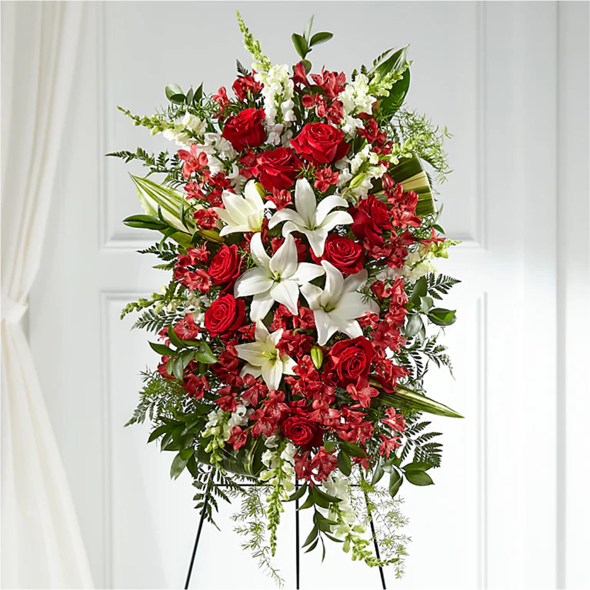 Standing spray of red roses and white lilies on an easel