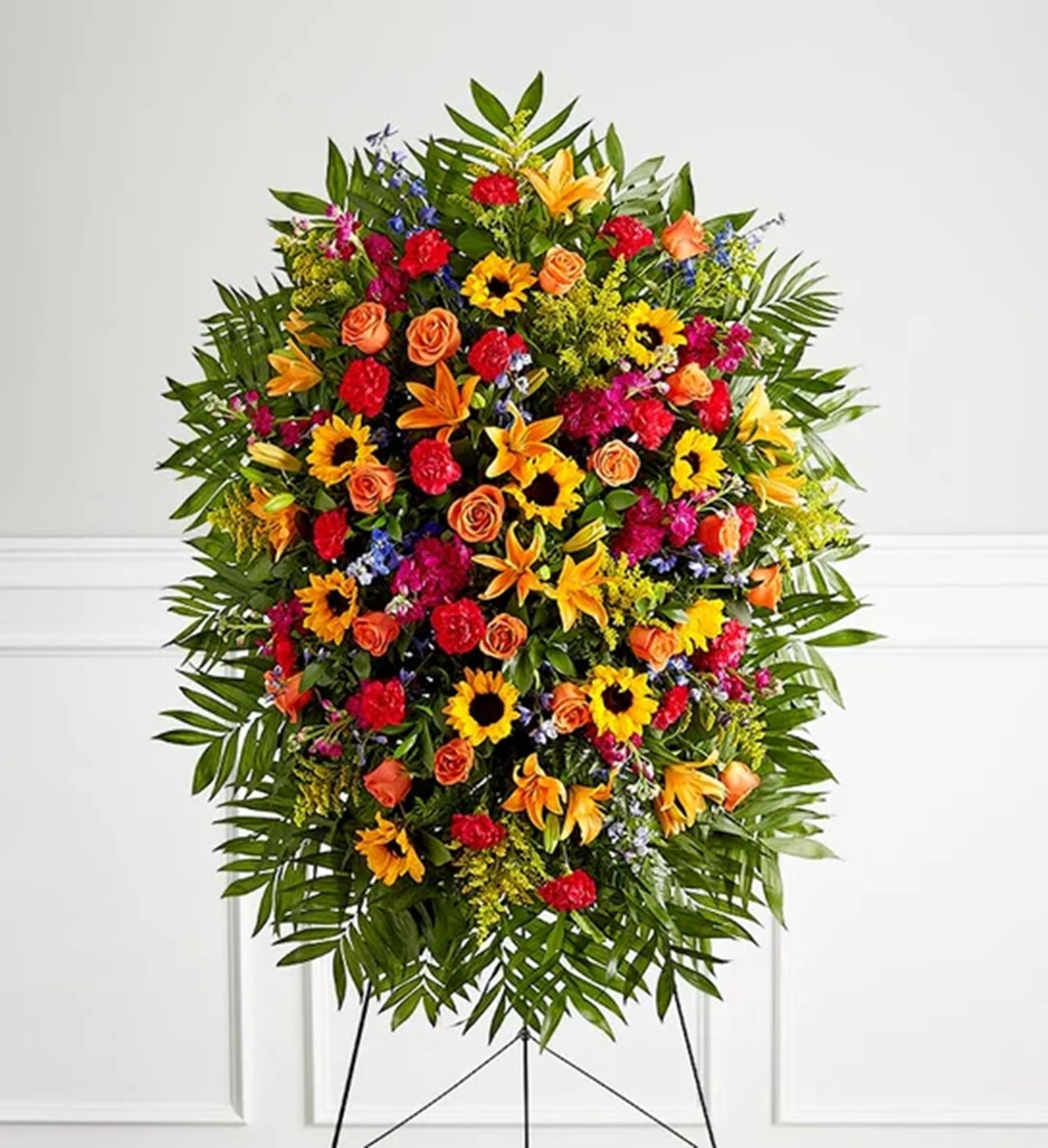 Large standing floral spray with sunflowers, roses, lilies, and carnations