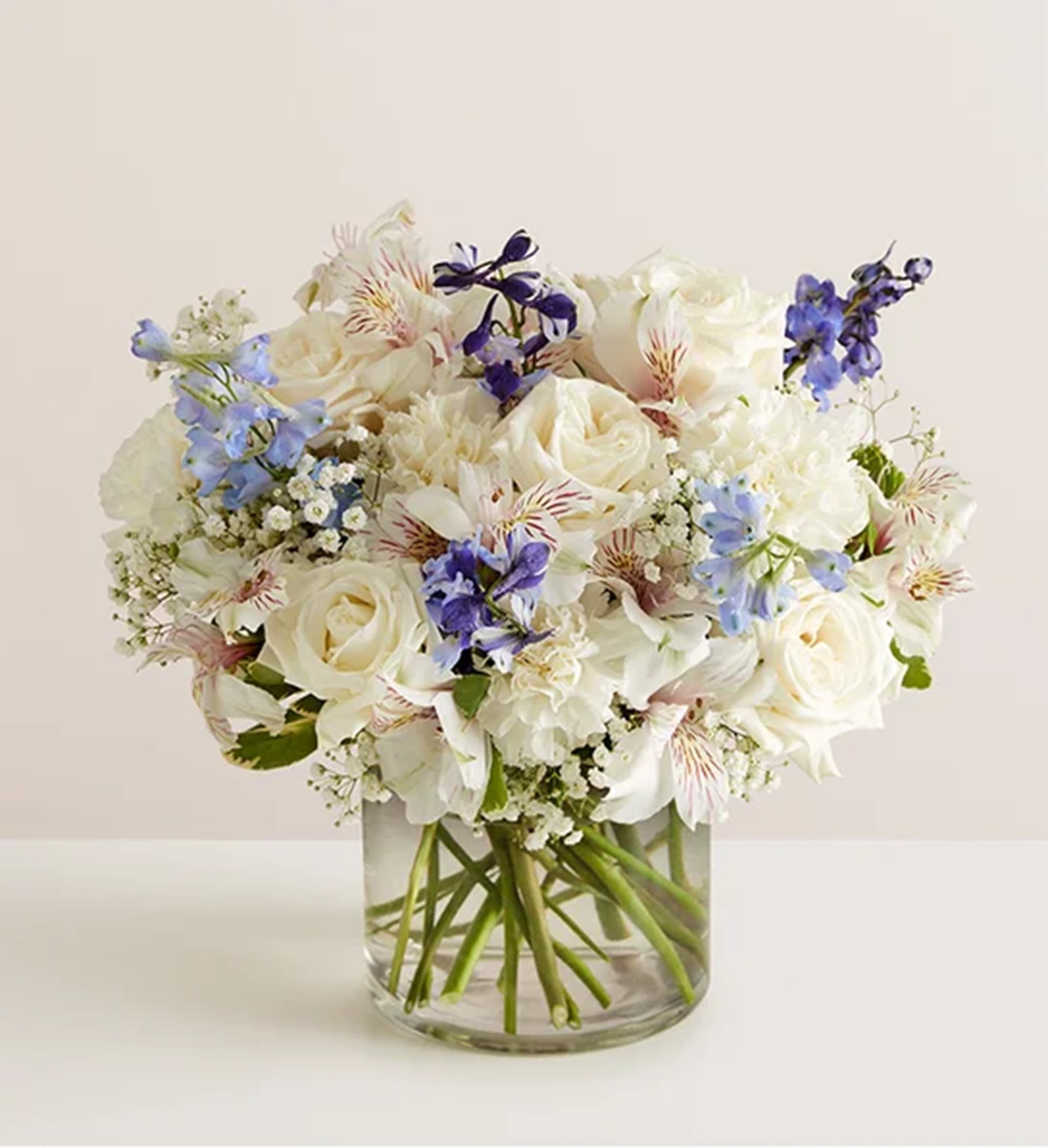 White and blue mixed bouquet in a clear glass vase