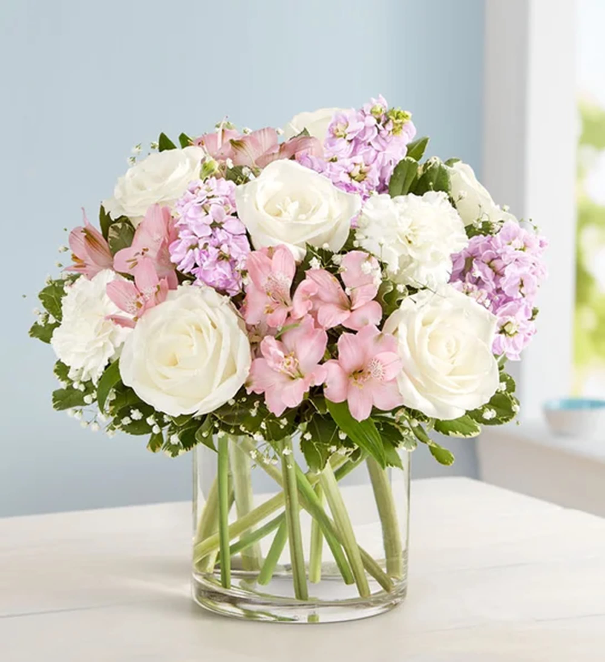 Bouquet of white roses and pink flowers in a clear glass vase