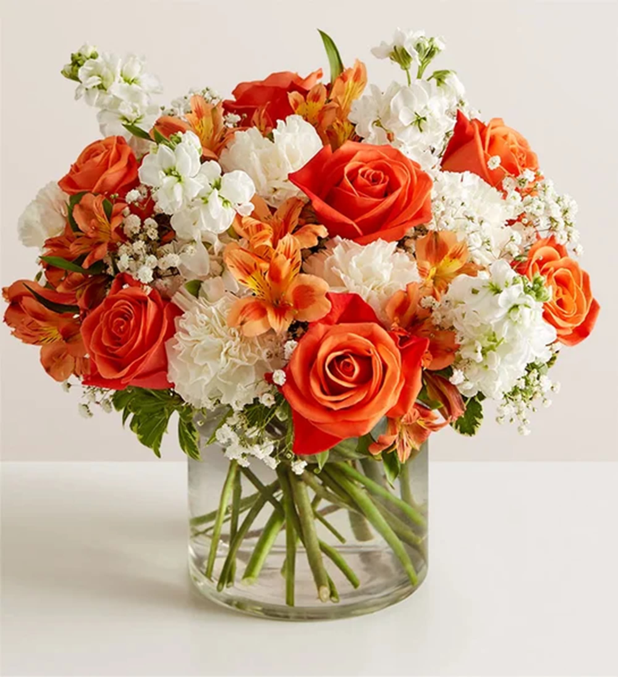 Orange and white mixed bouquet in a clear glass vase