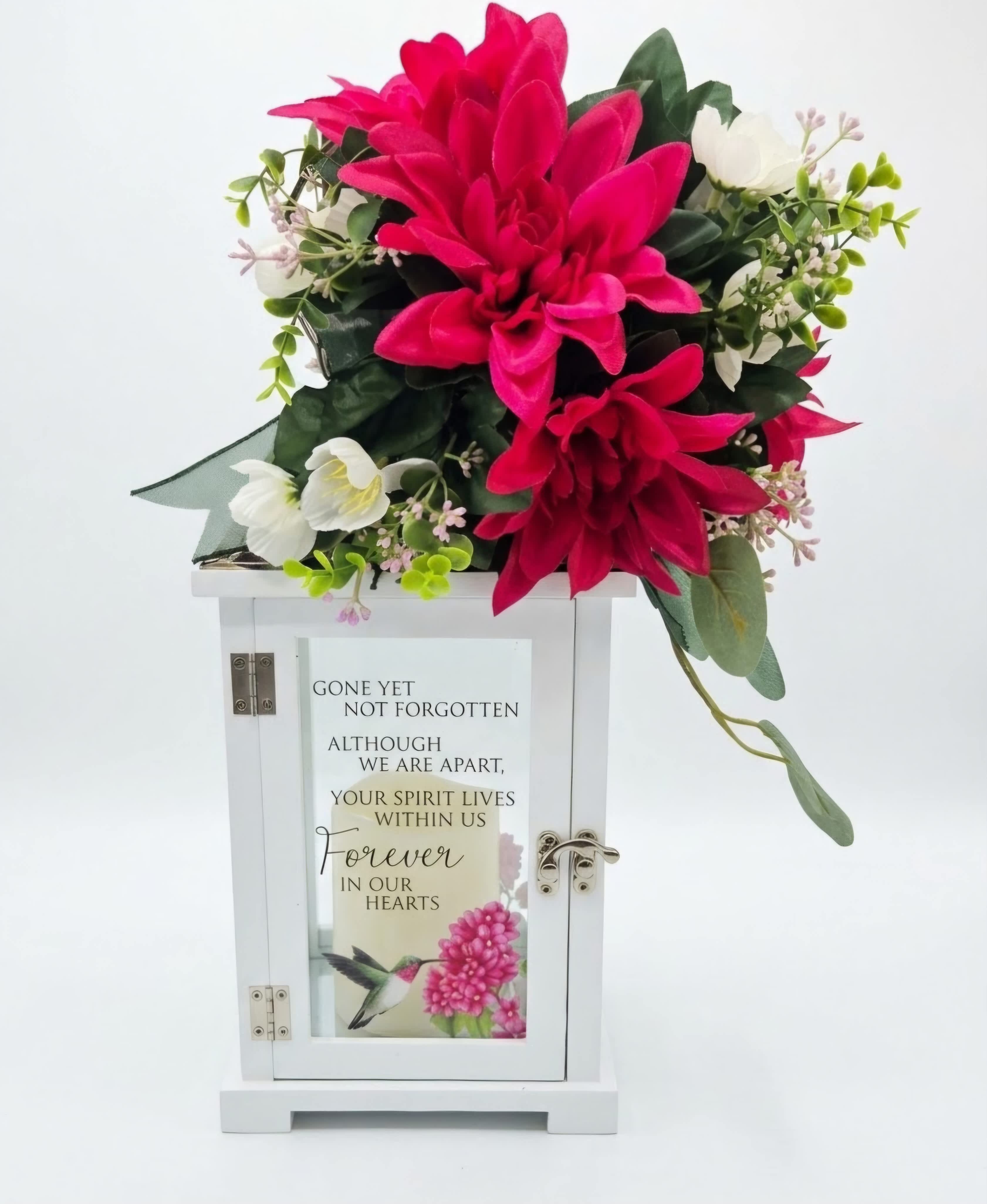 Pink and white floral arrangement on a white memorial lantern