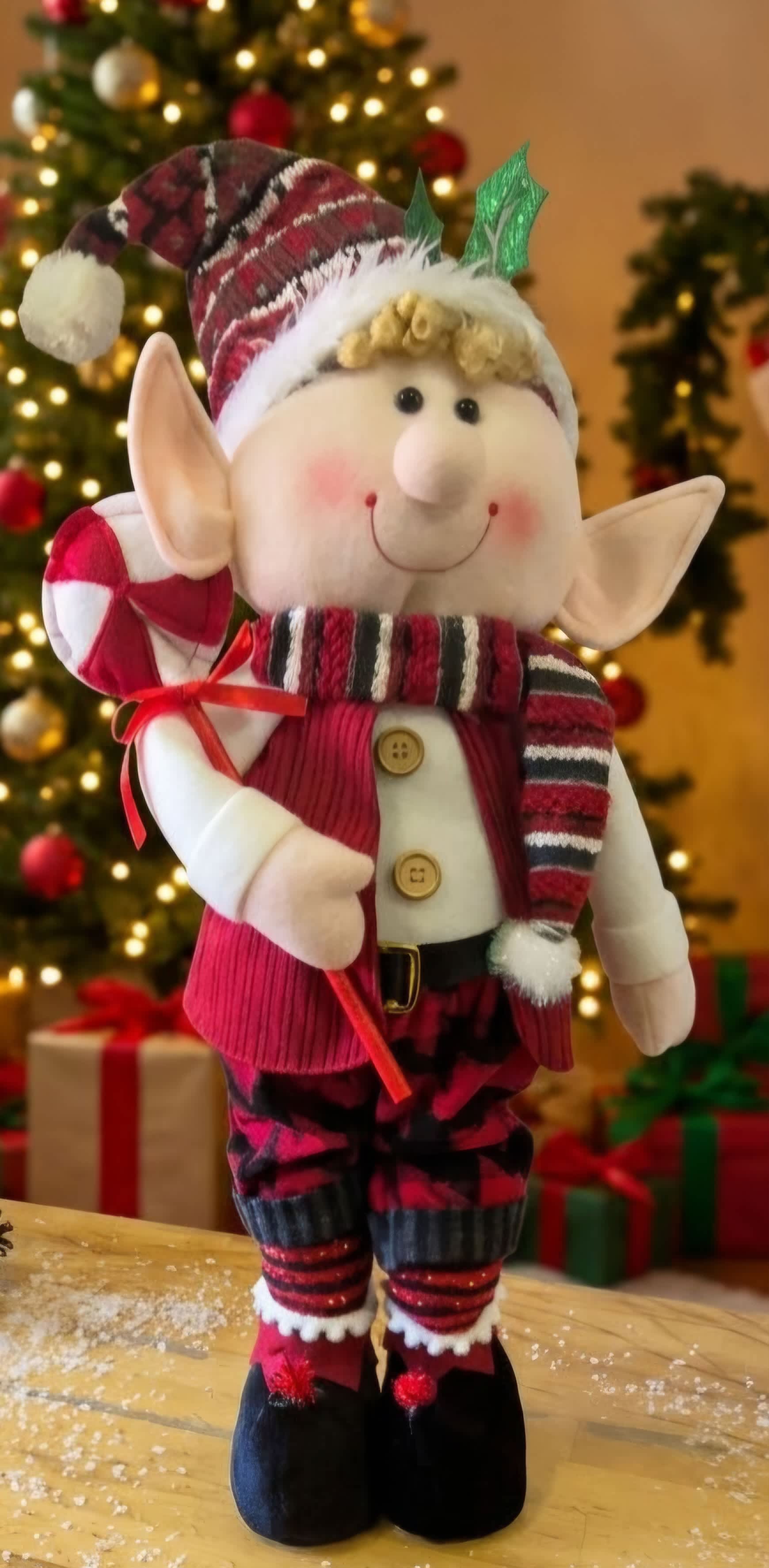 Christmas elf figurine in a striped hat and scarf