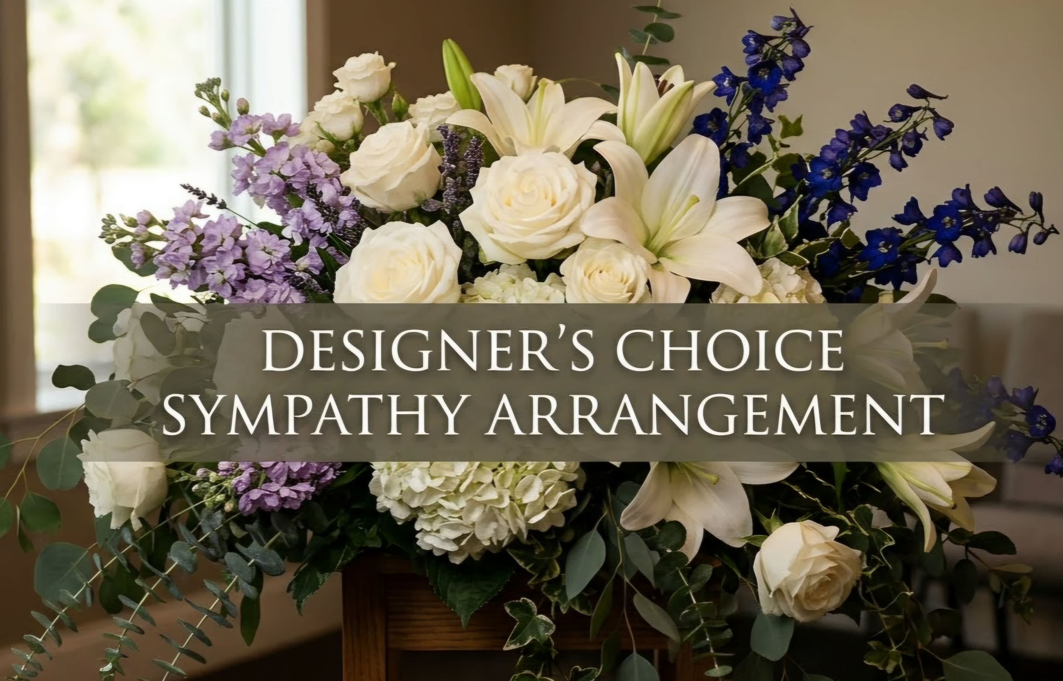White lilies and roses with purple flowers in a sympathy arrangement