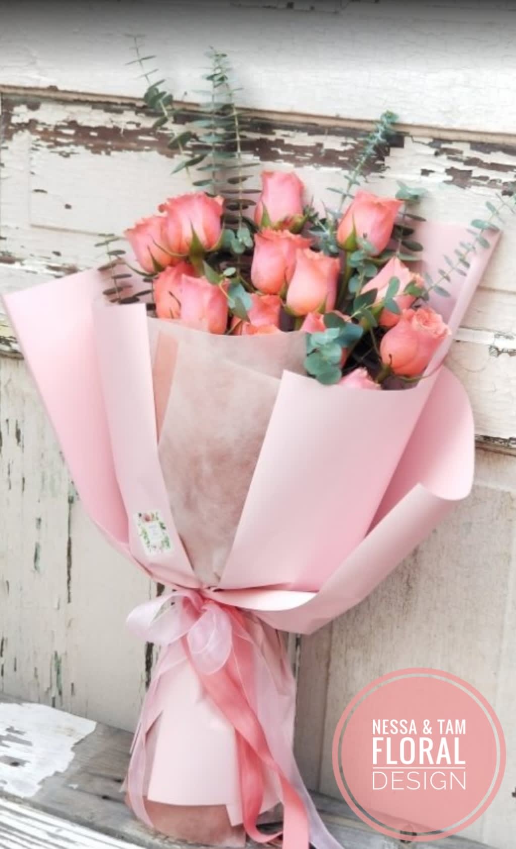 Pink rose bouquet wrapped in pastel pink paper with a ribbon