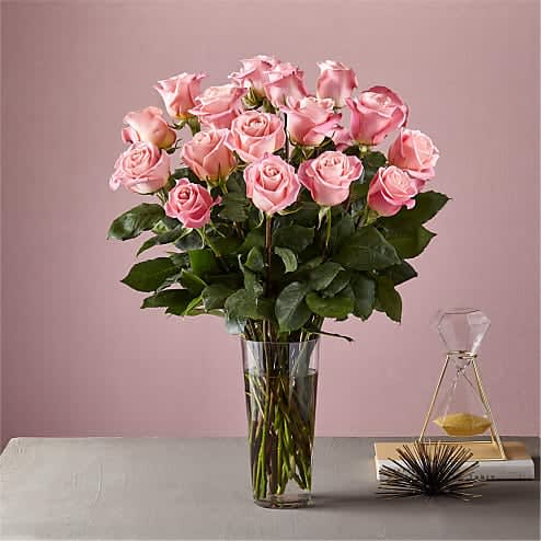 Dozen Long Stemmed Pink Roses by BloomNation™ - This arrangement is the perfect "pick me up" to brighten someone's day. Dozen Long Stemmed Pink Roses by BloomNation™ is the perfect gift for a birthday, get well, just because, and thank you.    Arrangement Details: 12 Long Stemmed Pink Roses and Assorted Greenery APPROXIMATE DIMENSIONS: 25" H X 18" W