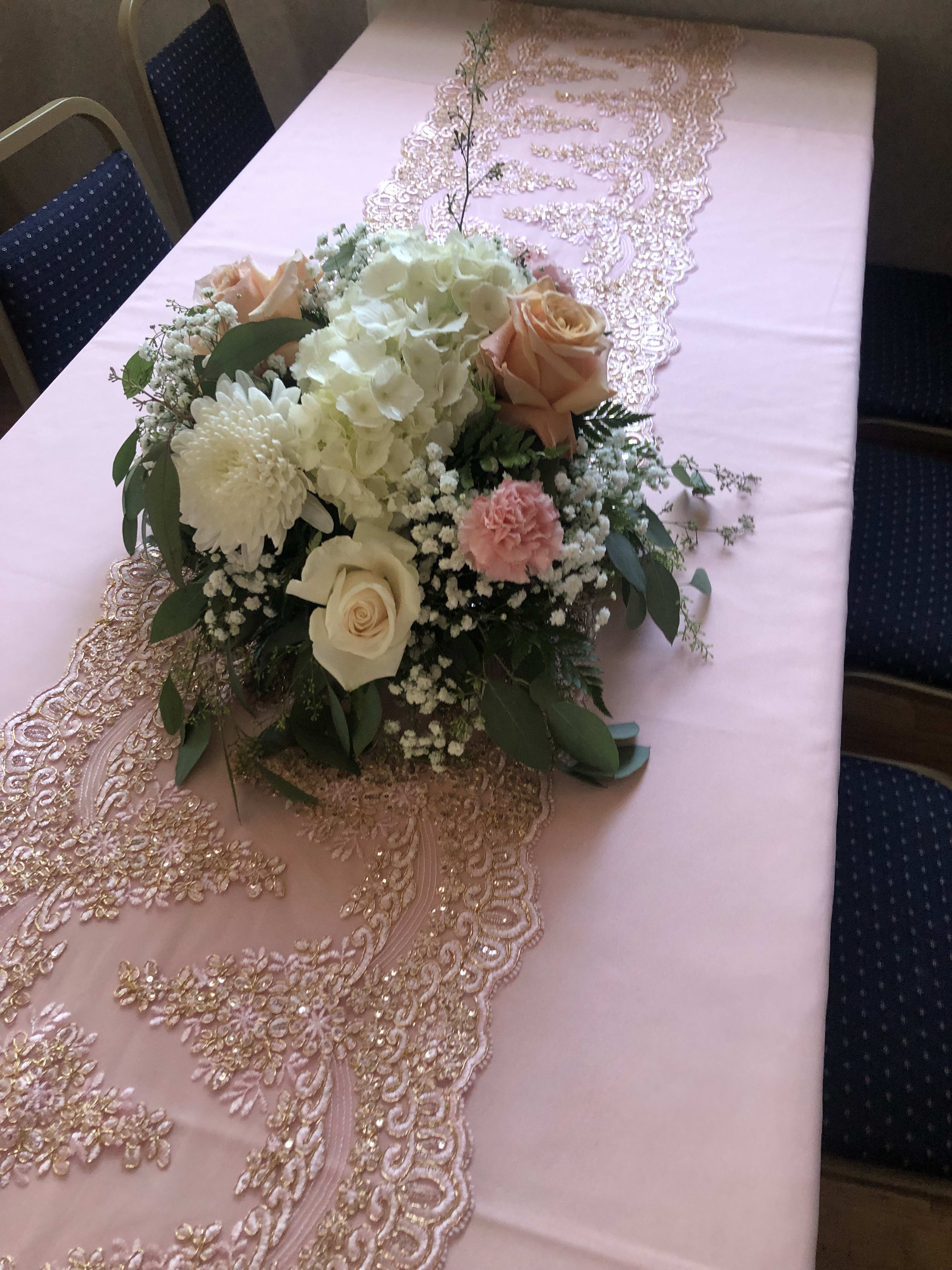 Pink and gold table runner with a pastel floral centerpiece