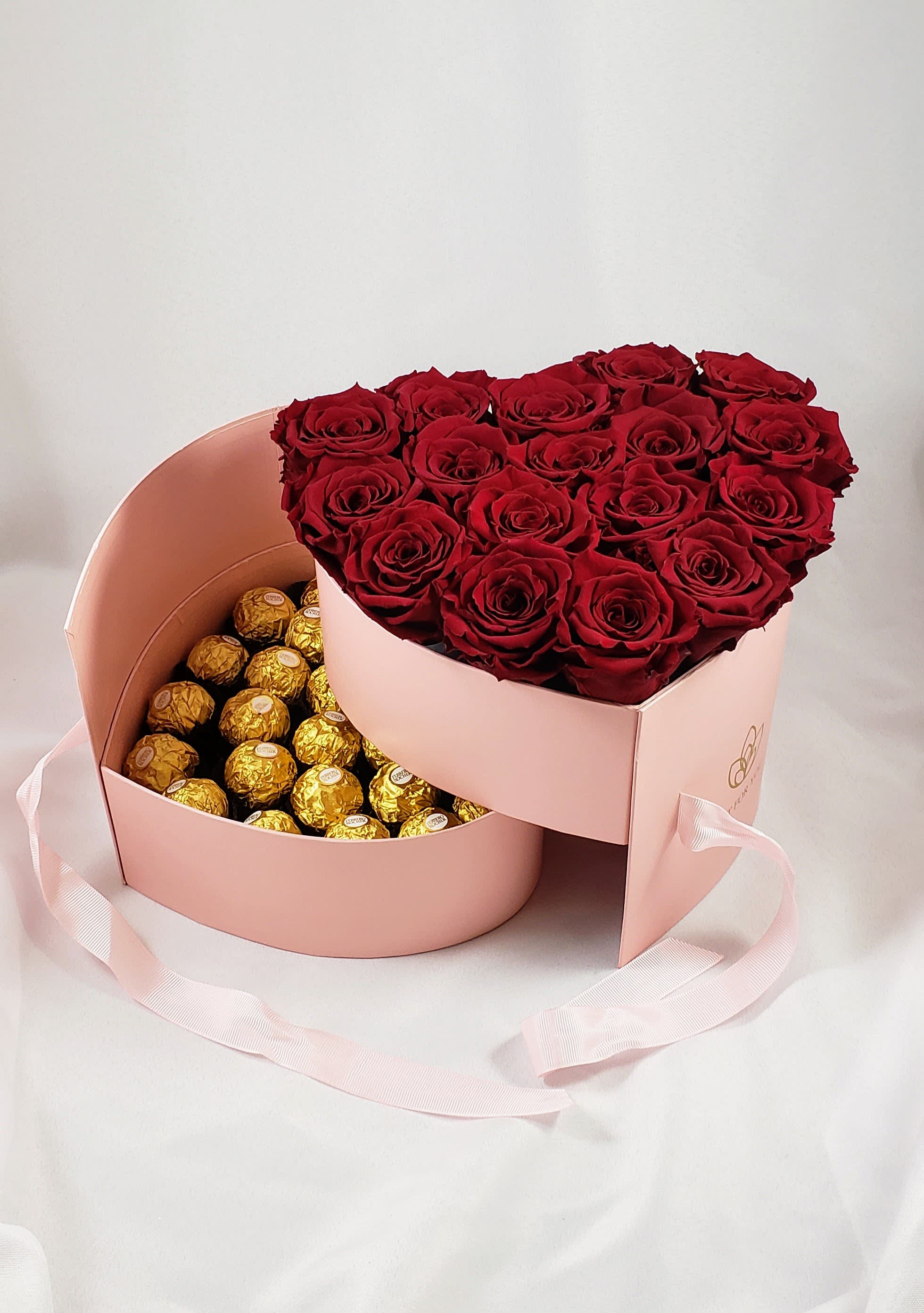 Heart-shaped box with red roses and gold-wrapped chocolates
