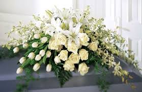 White floral casket spray with lilies and roses