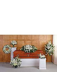 White funeral floral sprays and wreaths around a casket
