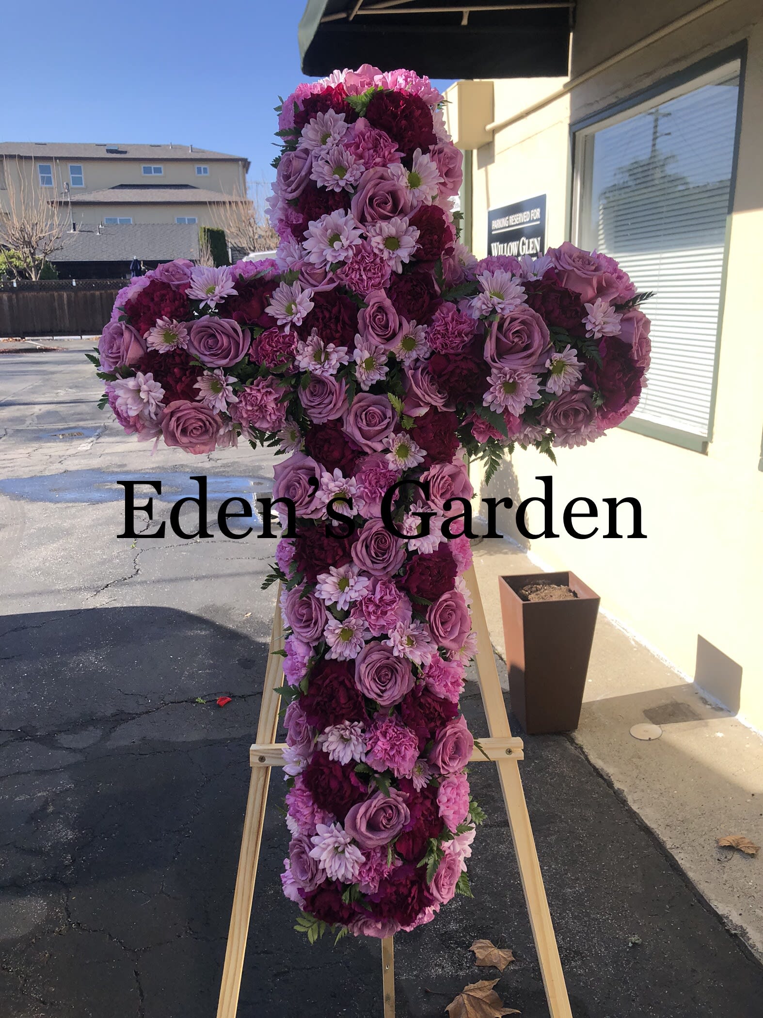 Pink and purple floral cross on a wooden easel
