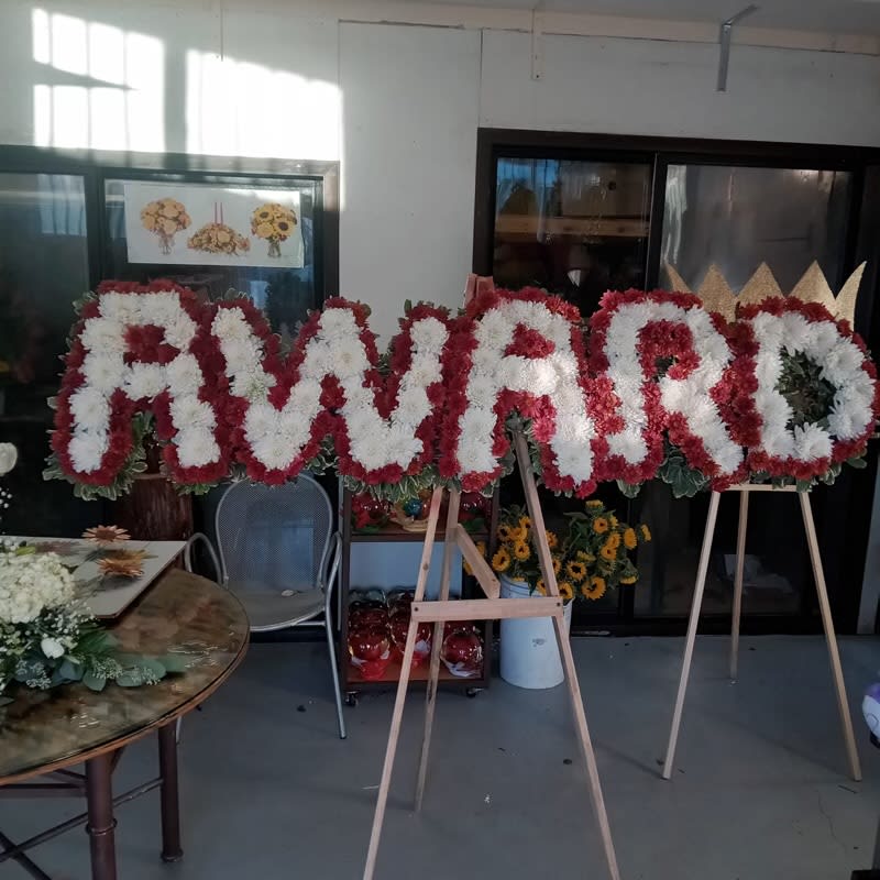 Large floral letters on easels spelling a name in red and white flowers