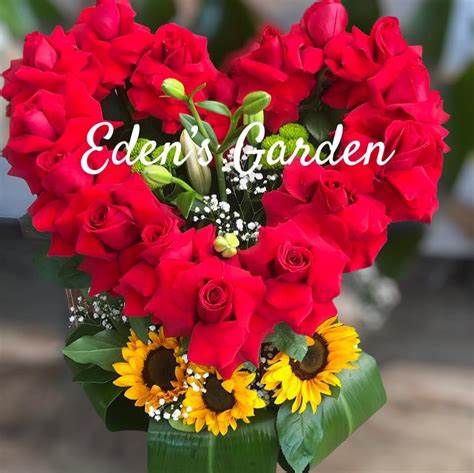 Heart-shaped bouquet of red roses with sunflowers at the base