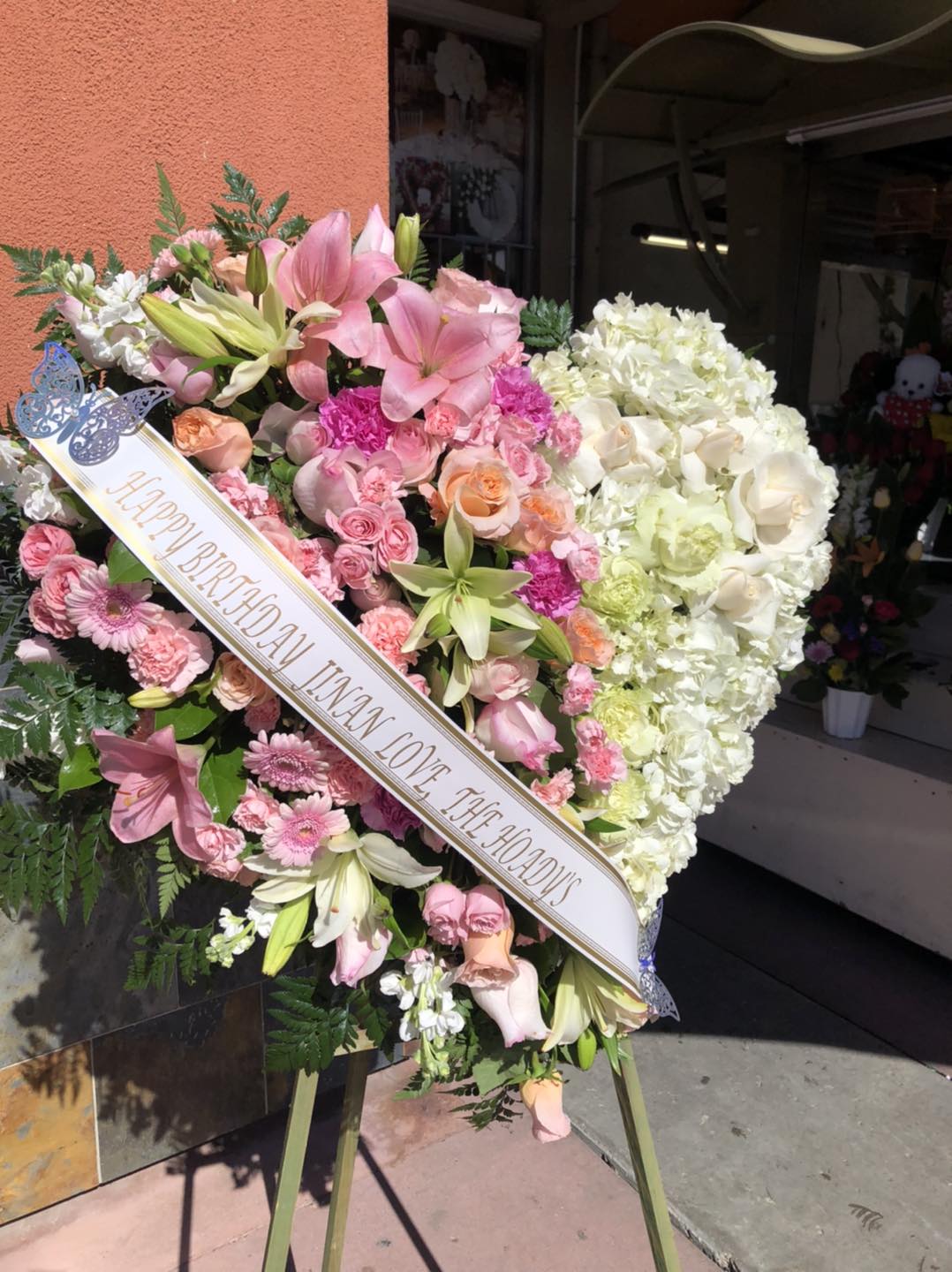 Large pink and white funeral heart wreath with a birthday ribbon