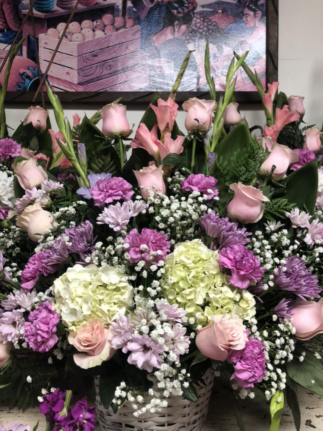 Basket arrangement of pink roses, lilies, hydrangeas, and purple mums