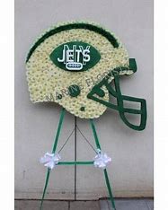 Football-shaped floral tribute on a stand with a Jets logo