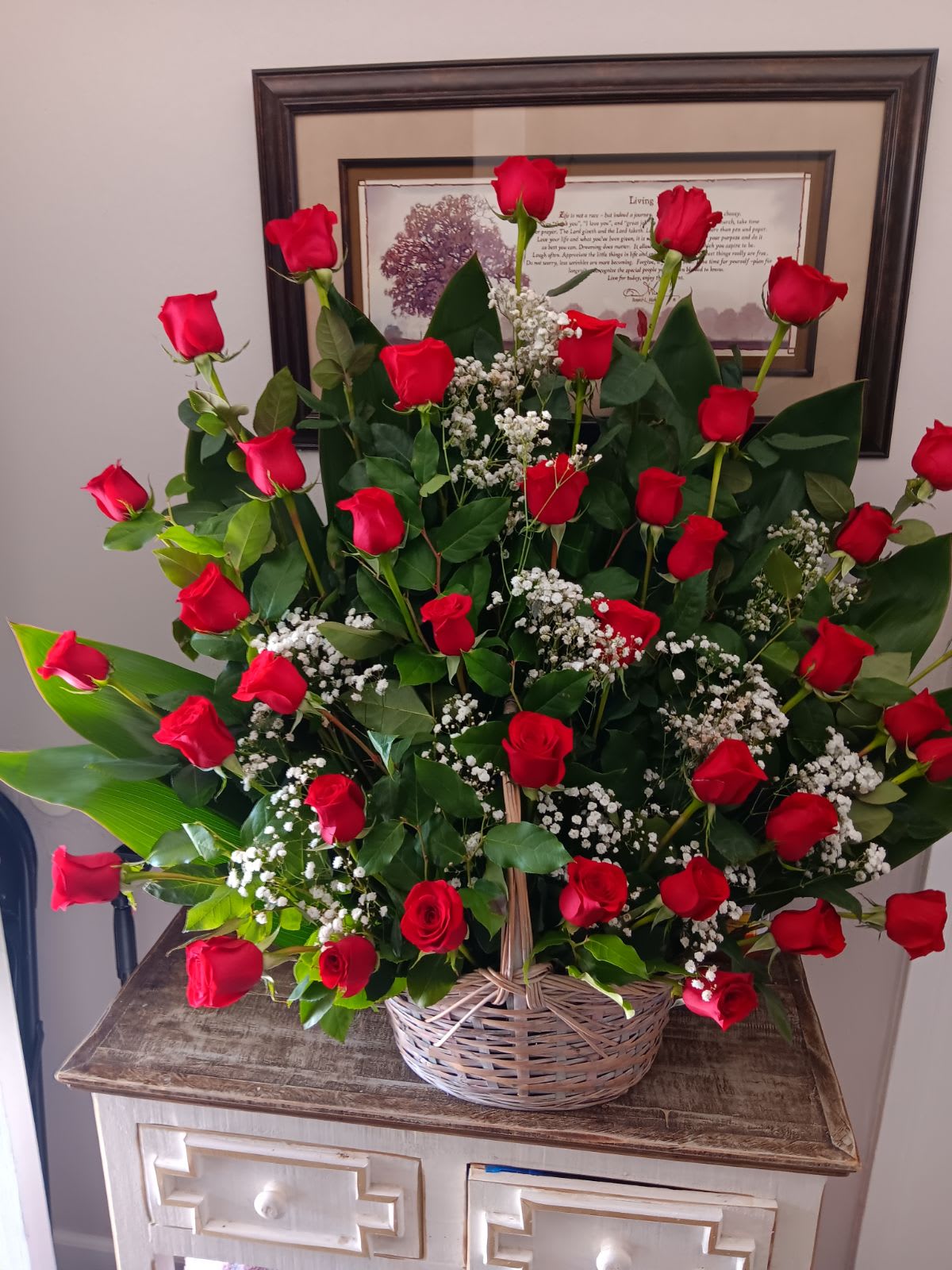 Basket arrangement of red roses and baby's breath