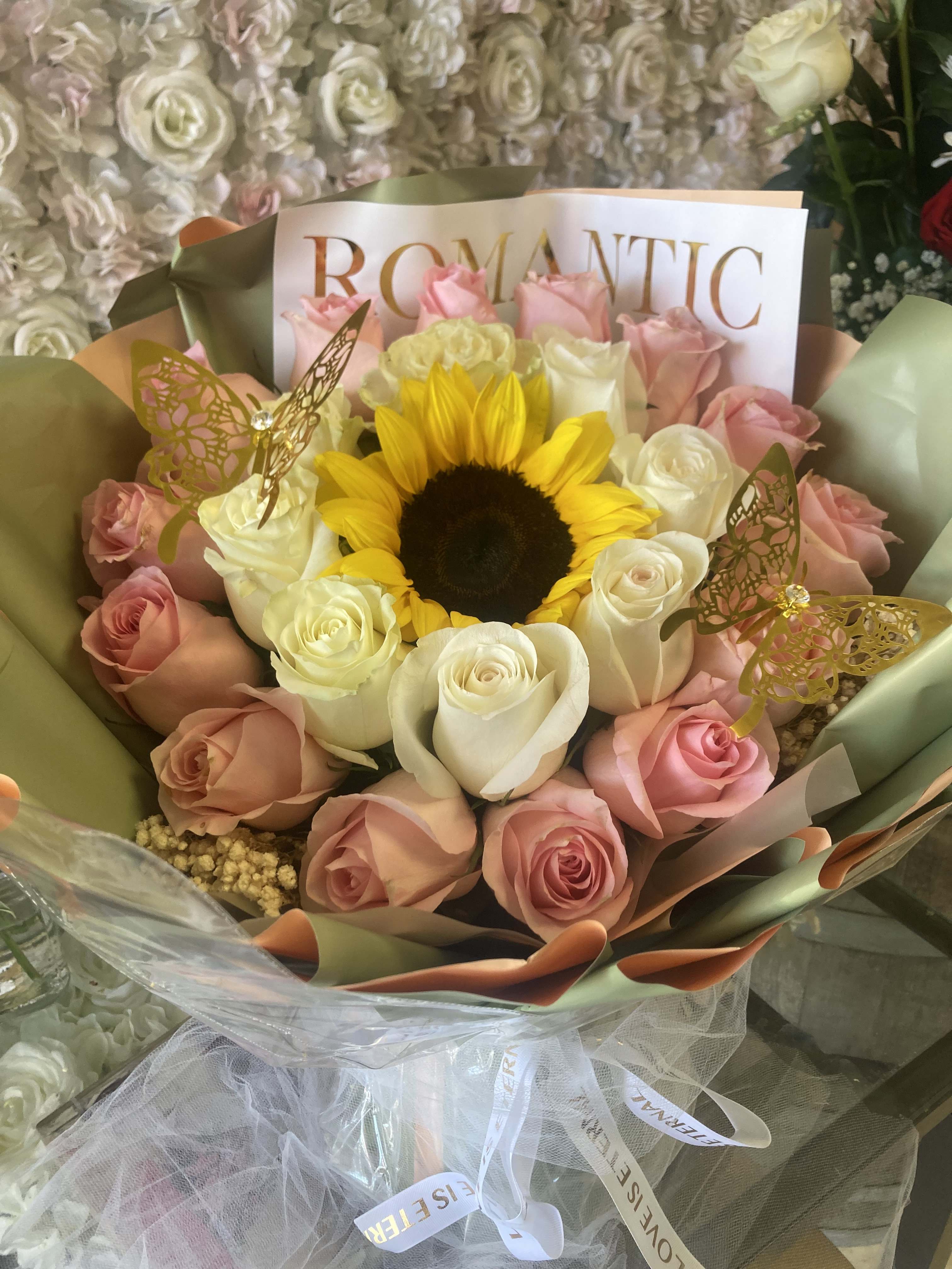 Bouquet of pink and white roses with a sunflower center