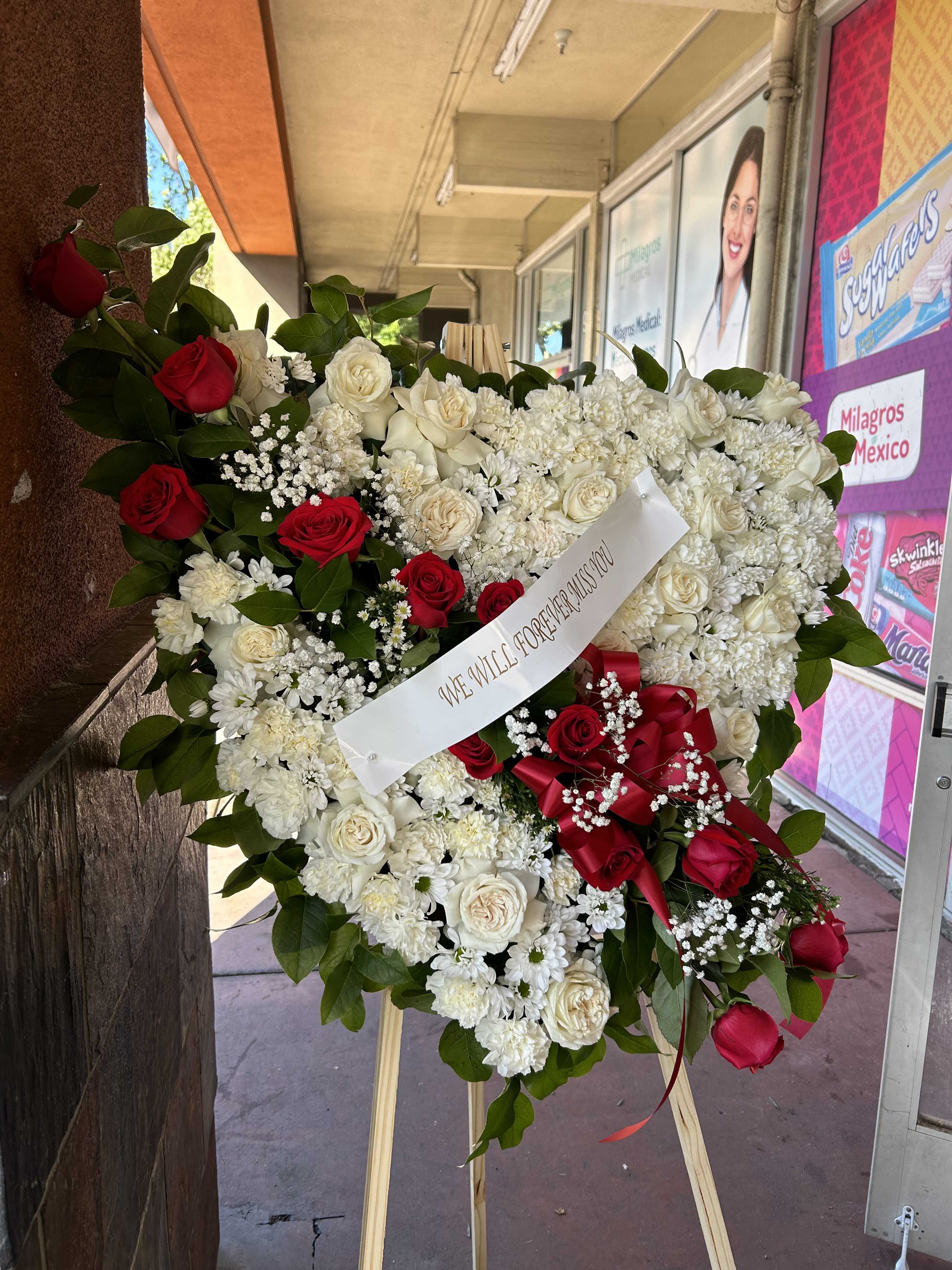 Heart-shaped standing wreath of red and white roses on an easel
